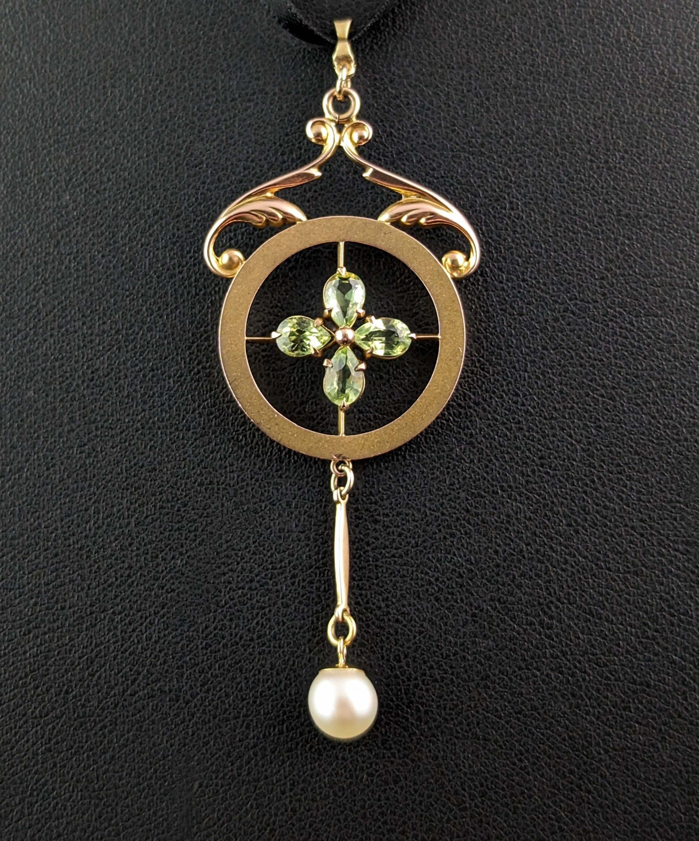 This beautiful antique peridot and pearl floral pendant is so pretty and elegant.

This pendant has a circular design top with scrolling gold arches atop and the most beautiful Peridot flower to the centre of the circle, the pear cut peridots make