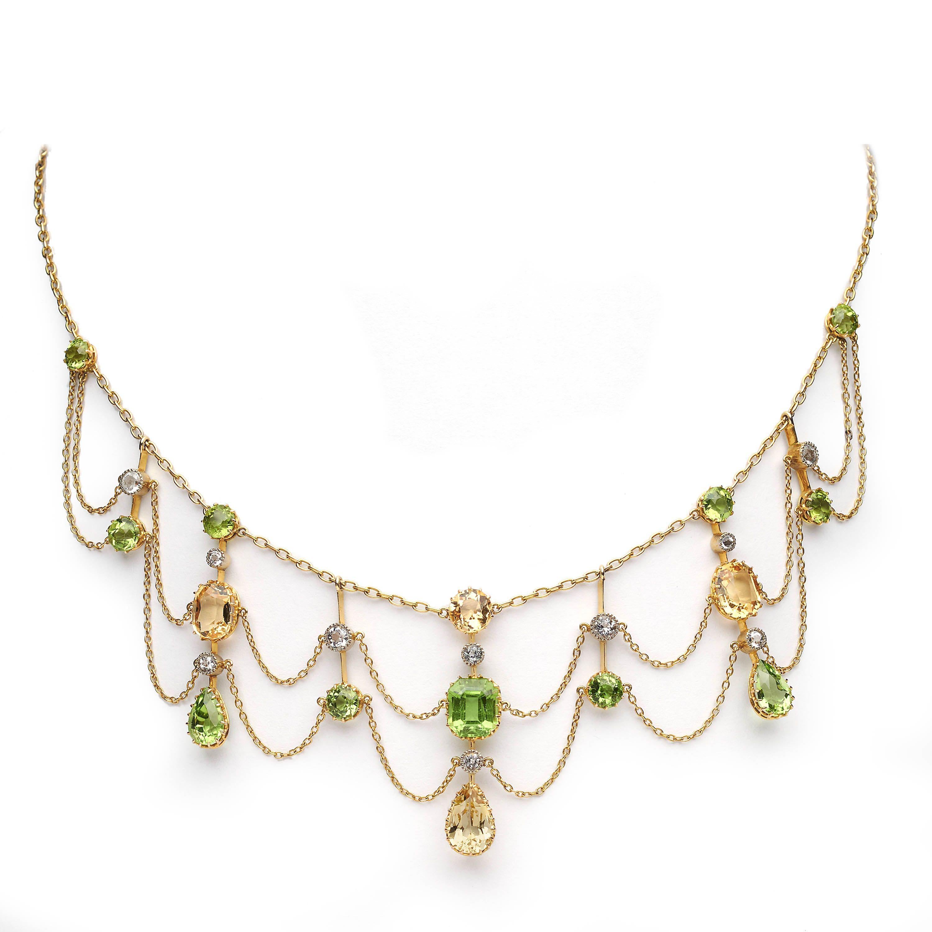 An antique, peridot, citrine, white sapphire and gold festoon necklace, with round, cushion and drop shaped faceted peridots and citrines, in gallery claw settings, and white sapphires, in millegrain edged rub over settings, in knife edge pendants,