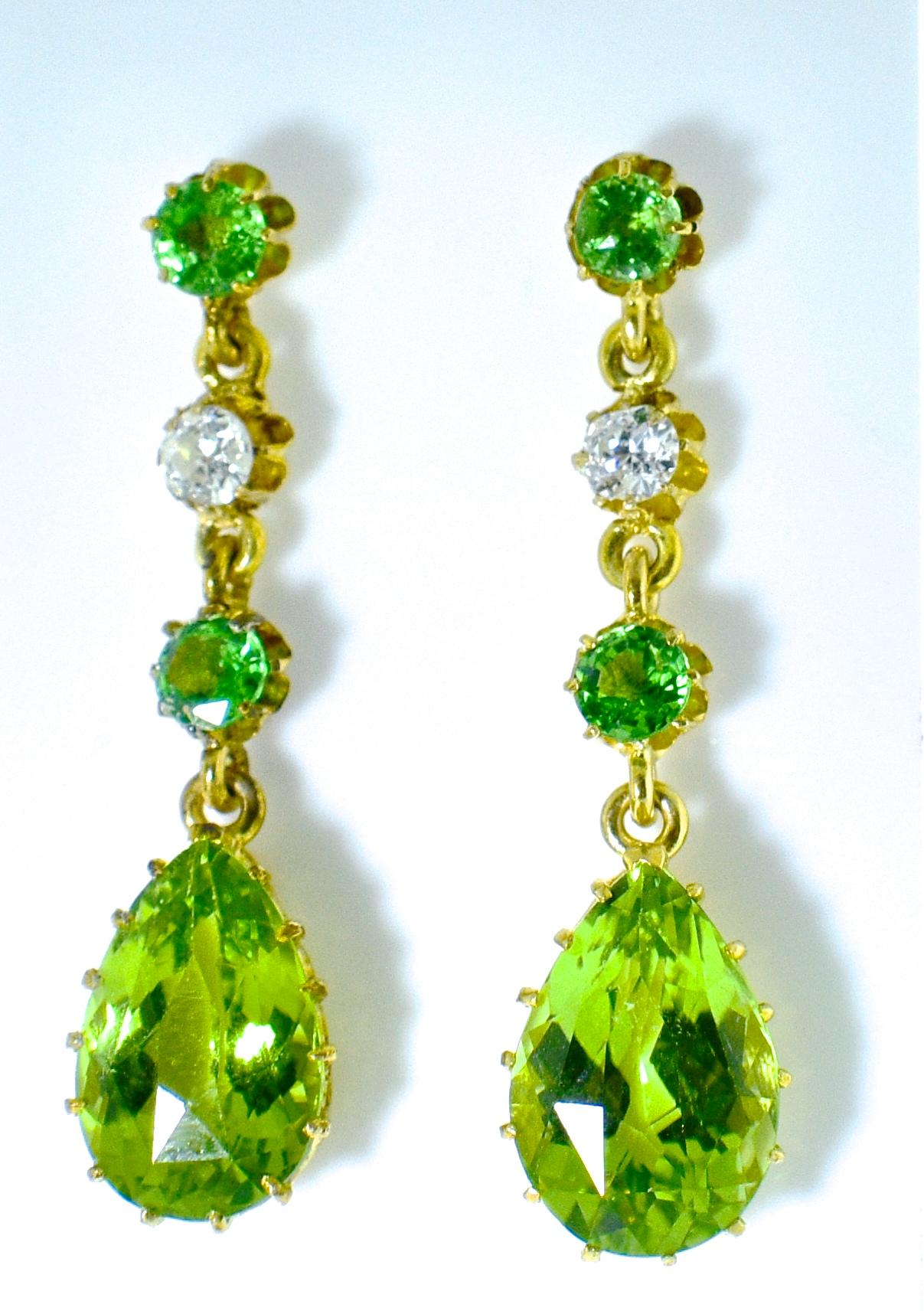 Antique natural bright green Peridots are set in multi prongs in these pendant style earrings.  The 6 peridots weigh approximately 7.5 cts.  There are also two white old European cut diamonds weighing approximately .30 cts.  These earrings are 1.25