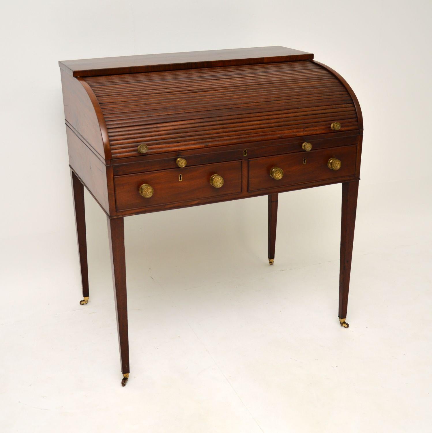 A stunning antique George III period roll top writing desk in solid wood. This was made in England & I would date it to around the 1790’s period.

This is of extremely fine quality and is a very useful item. The tambour top rolls back to reveal a