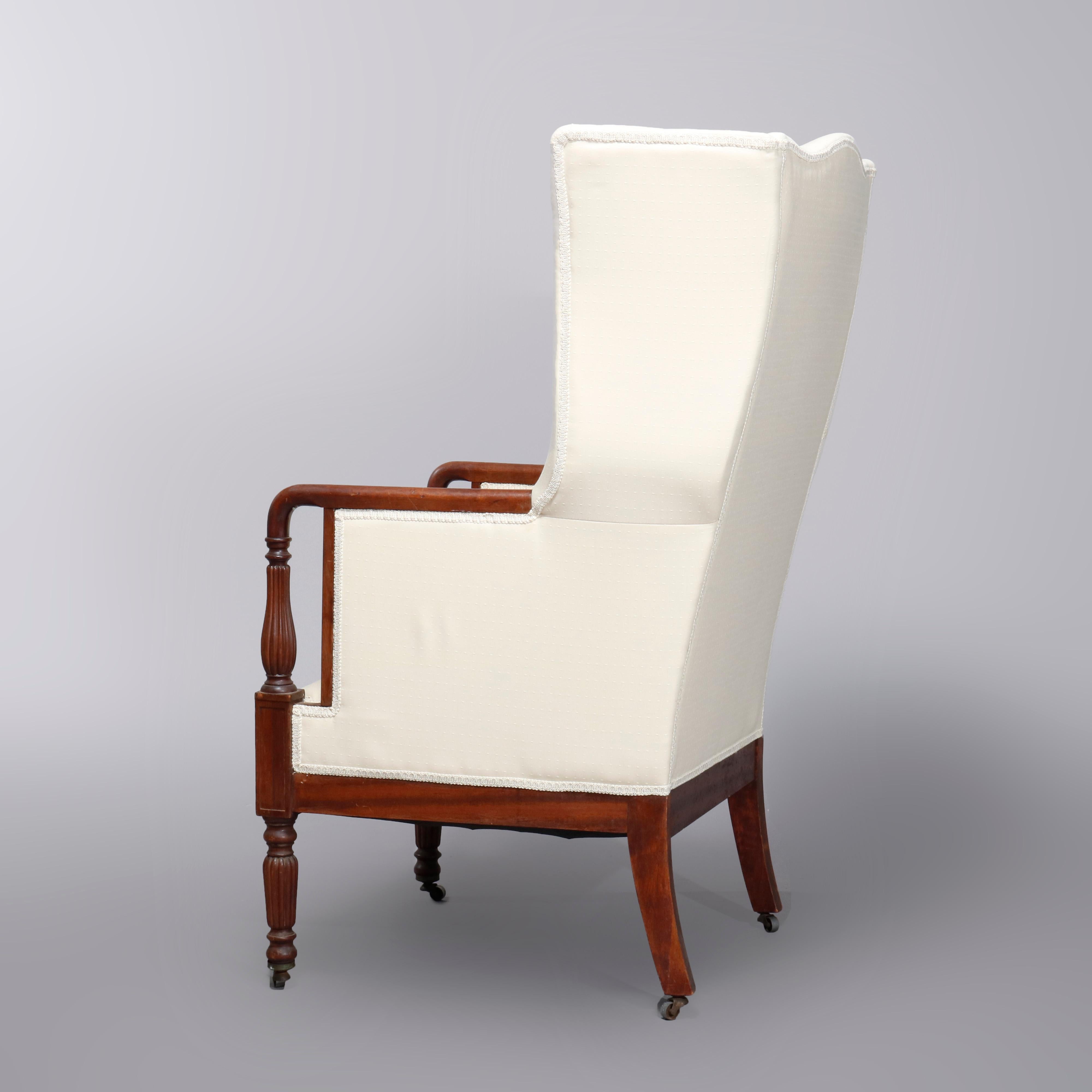 An antique period Sheraton fireside chair offers wingback form with original finish mahogany frame, newly re-upholstered, circa 1830. 

Measures- 47.5