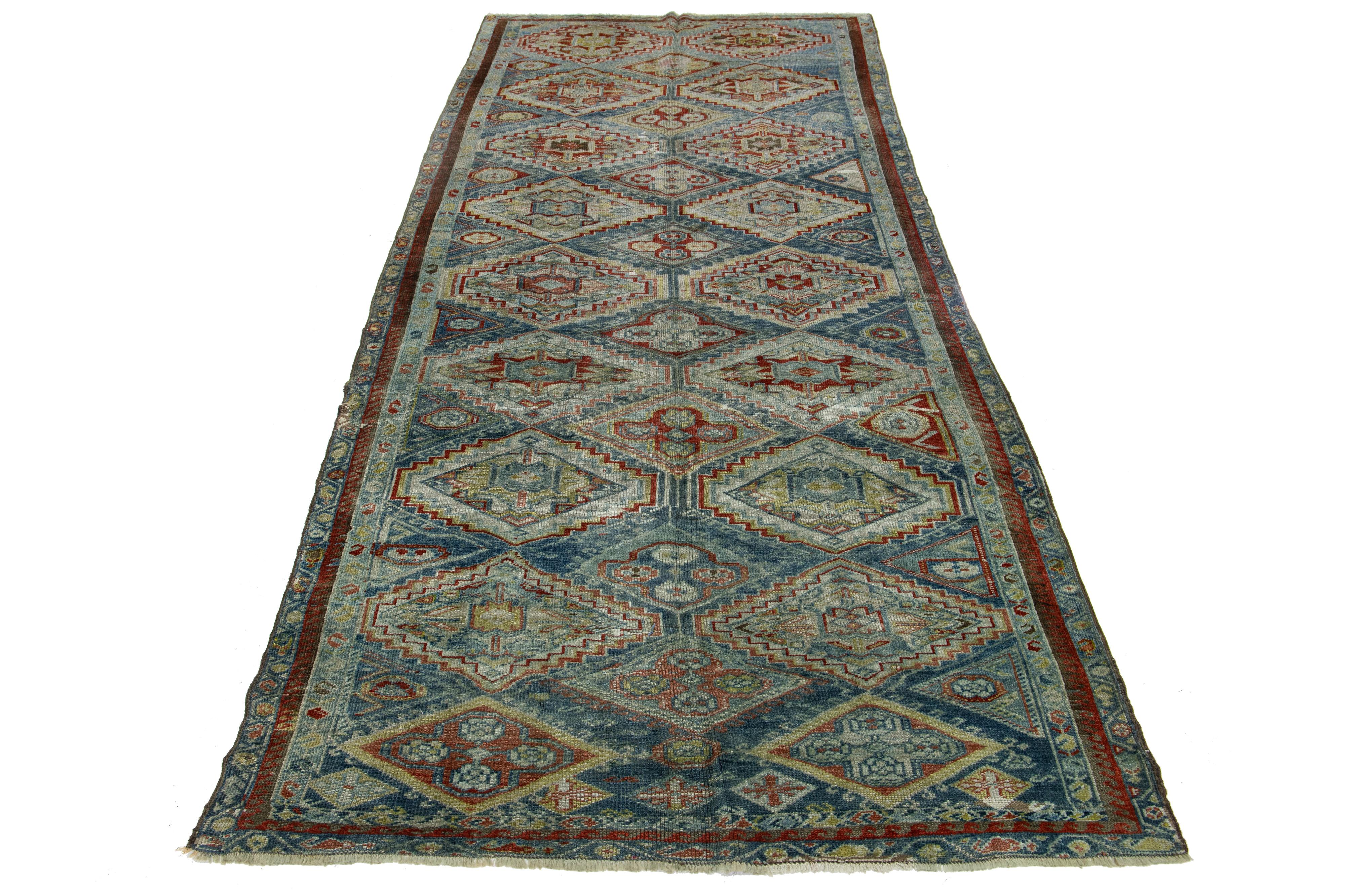 Preciosa alfombra persa antigua de lana anudada a mano con un campo de color azul. Esta pieza tiene un marco de diseño rojo con detalles multicolores en un precioso estampado integral.

Esta alfombra mide 5'2