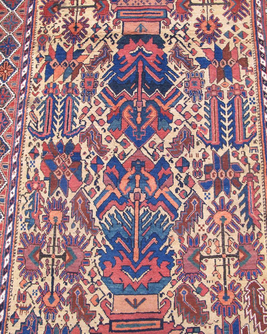 Antique Persian Afshar Rug, Late 19th Century

Woven against a rustic camel ground, this Afshar rug draws two stylized potted plants, from top and bottom, each culminating at the center in colorful floral bursts of indigo, green, burgundy, and