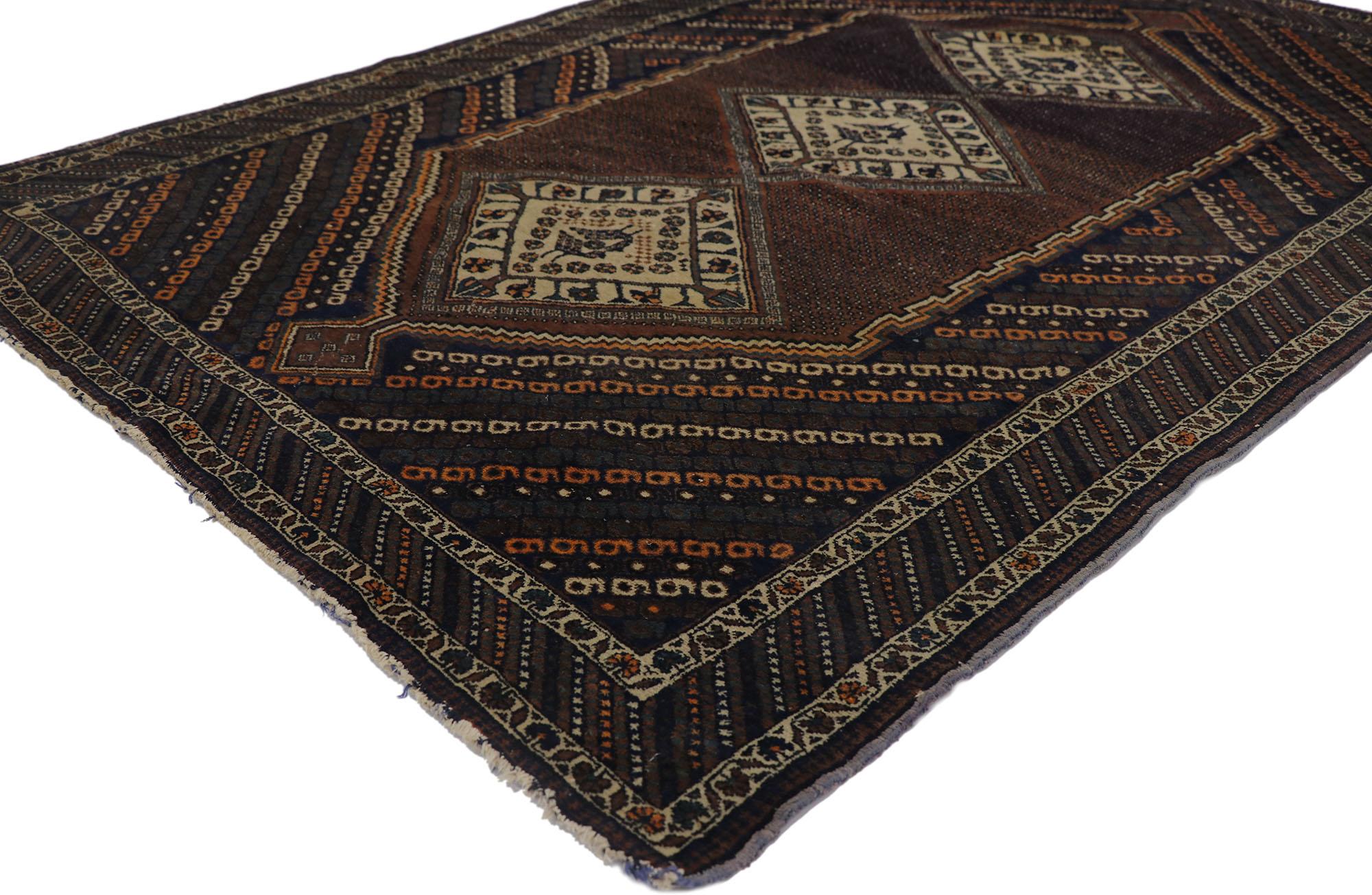 21687 Antique Persian Afshar rug with Nomadic Tribal style 04'01 x 05'10. Warm and inviting with a dark and moody color palette, this hand-knotted wool antique Persian Afshar is poised to impress. The abrashed brown field features three sandy-beige