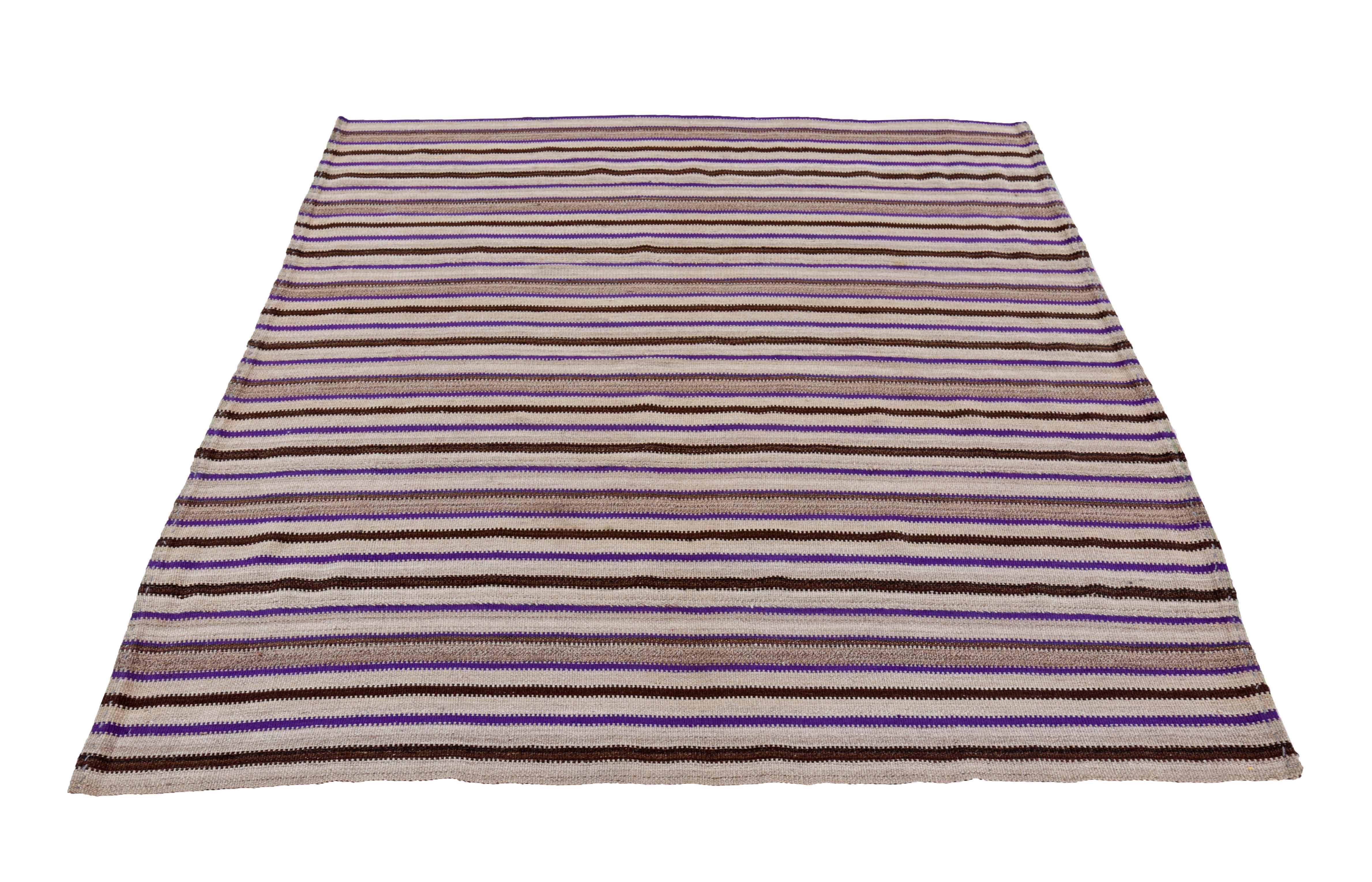 Entdecken Sie die Eleganz eines persischen Kilims mit einem kleinen Teppich von CIRCA 1910. Dieses exklusive Design aus Wolle und braun-elfenbeinfarbenem Purpur eignet sich perfekt, um Ihren Raum zu verschönern.
