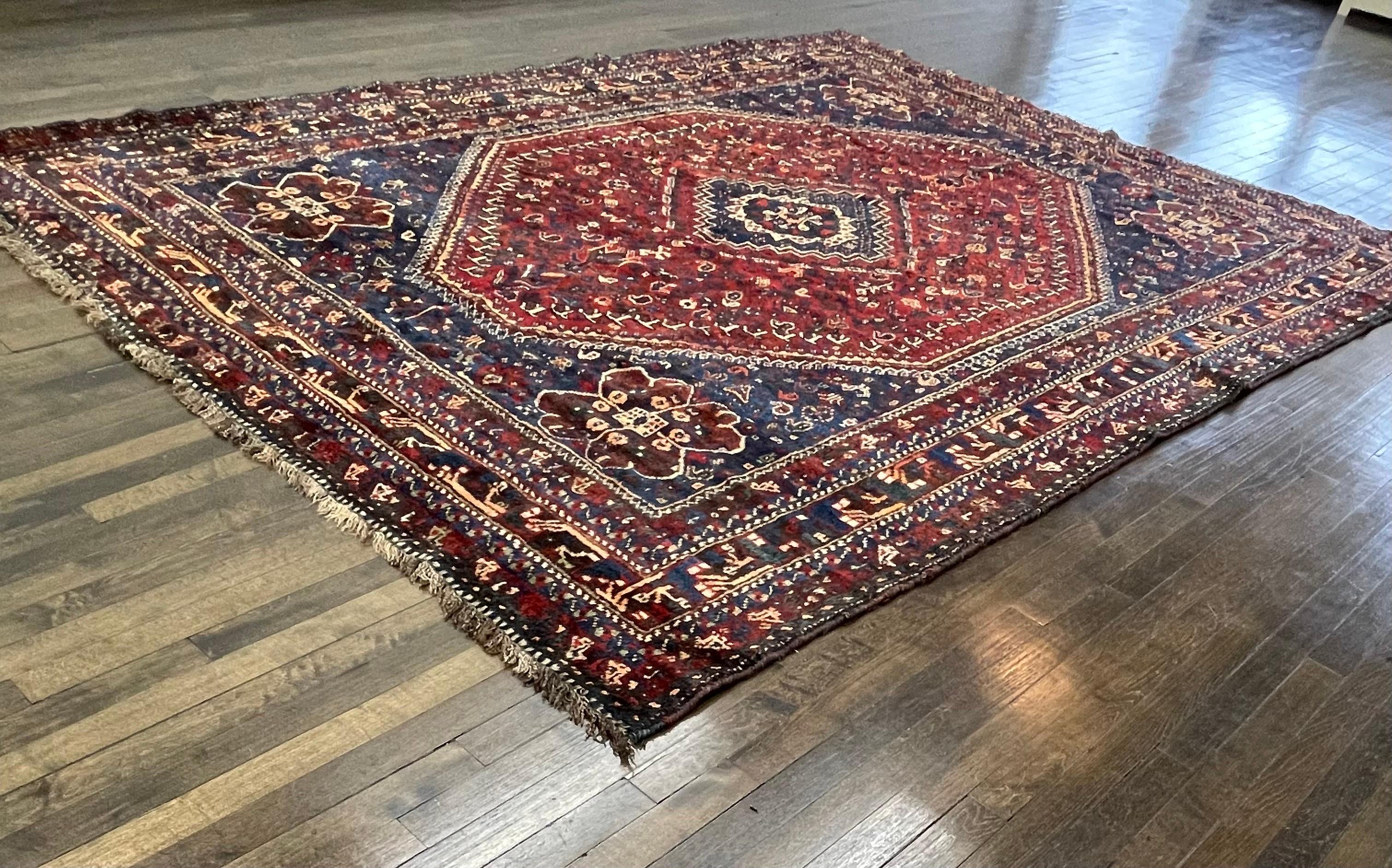 Handwoven in southern Persia this carpet is a beautiful example of Afshar tribe weaving. The solar Turkman gul dominate the center field surrounded with lots of tribal symbols.

The soft wool used to make this carpet, both to make the foundation