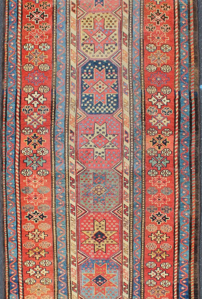 Antiker kaukasischer Kazak-Läufer mit Medaillons in Rot, Blau und Gelb. Keivan Woven Arts / Teppich L11-1205, Herkunftsland / Art: Iran / Stammeskunst, um 1900
Maße: 3'6 x 16.
Dieser antike kaukasische Kazak-Läufer weist mehrere sich wiederholende