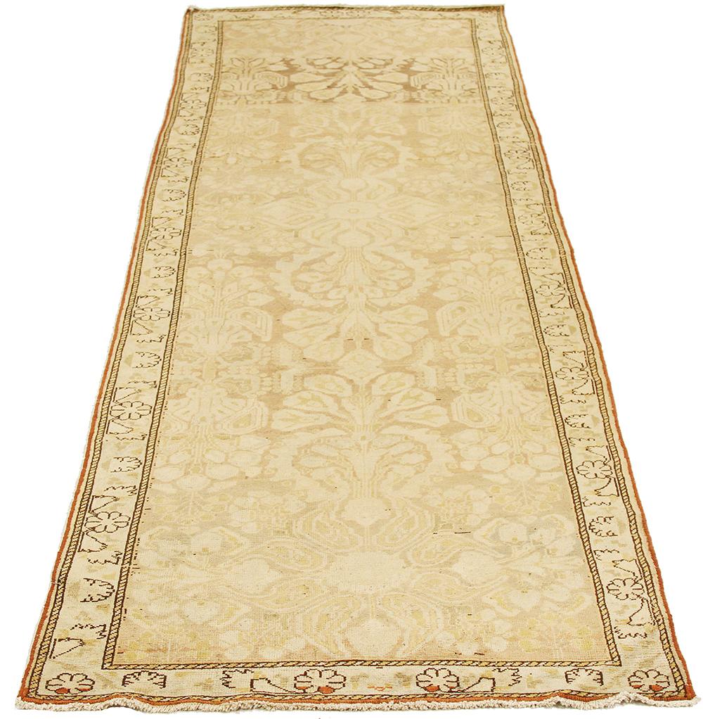 Antique Persian runner rug handwoven from the finest sheep’s wool and colored with all-natural vegetable dyes that are safe for humans and pets. It’s a traditional Bakhtiar design featuring faded floral details in brown and ivory. It’s a beautiful