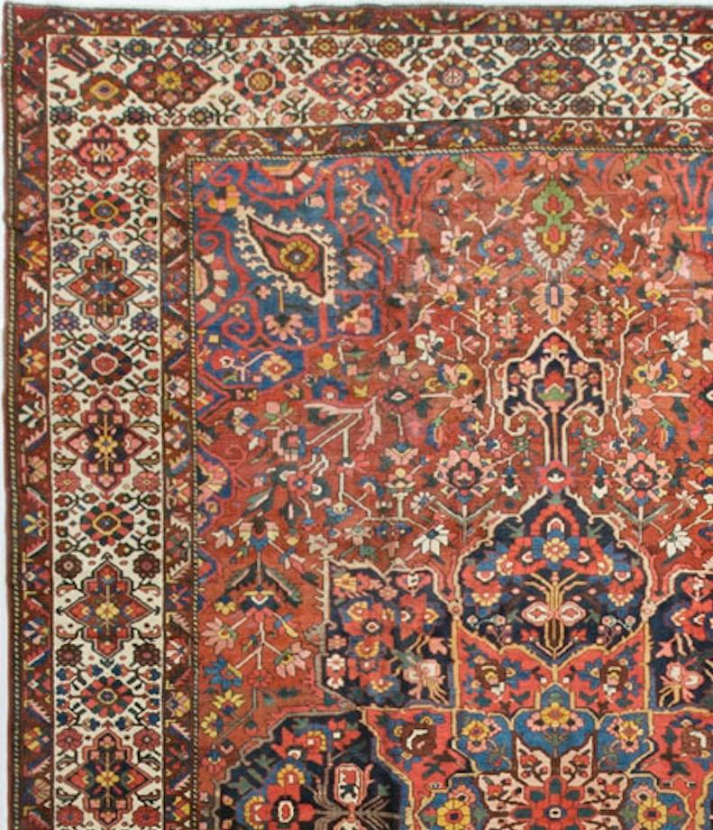 This striking piece on a red ground begins with a central motif of large flower heads in a deep blue surrounded by an array of flowers. The ivory border and enclosing minor borders repeat the floral theme setting this rug off to perfection.
