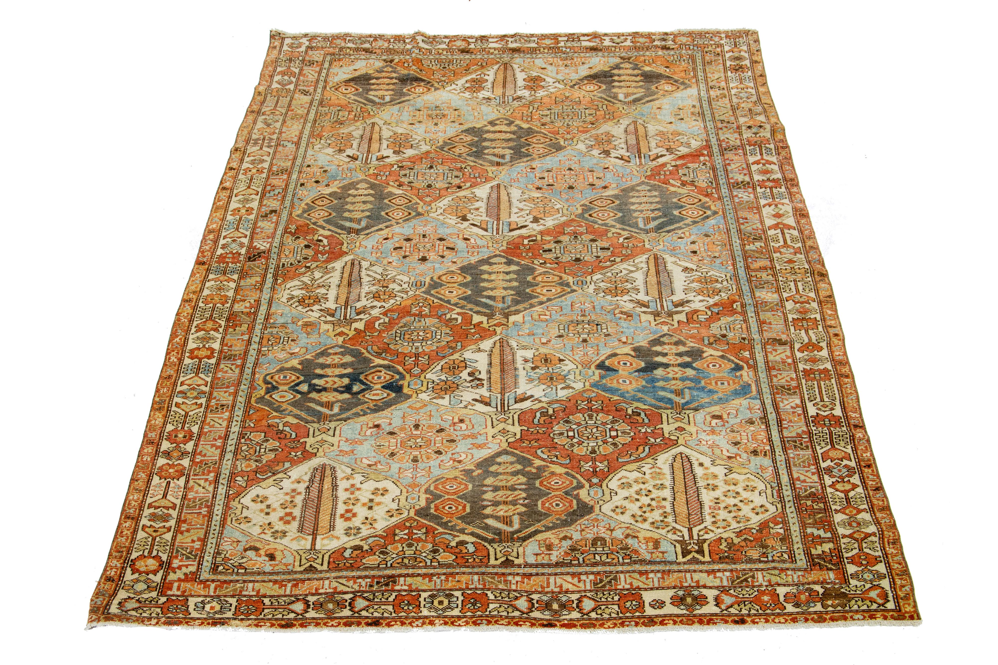 Beautiful Antique Bakhtiari hand-knotted wool rug with a rust color field. This Persian piece has a classic geometric floral design in blue and beige colors.

This rug measures 6'10