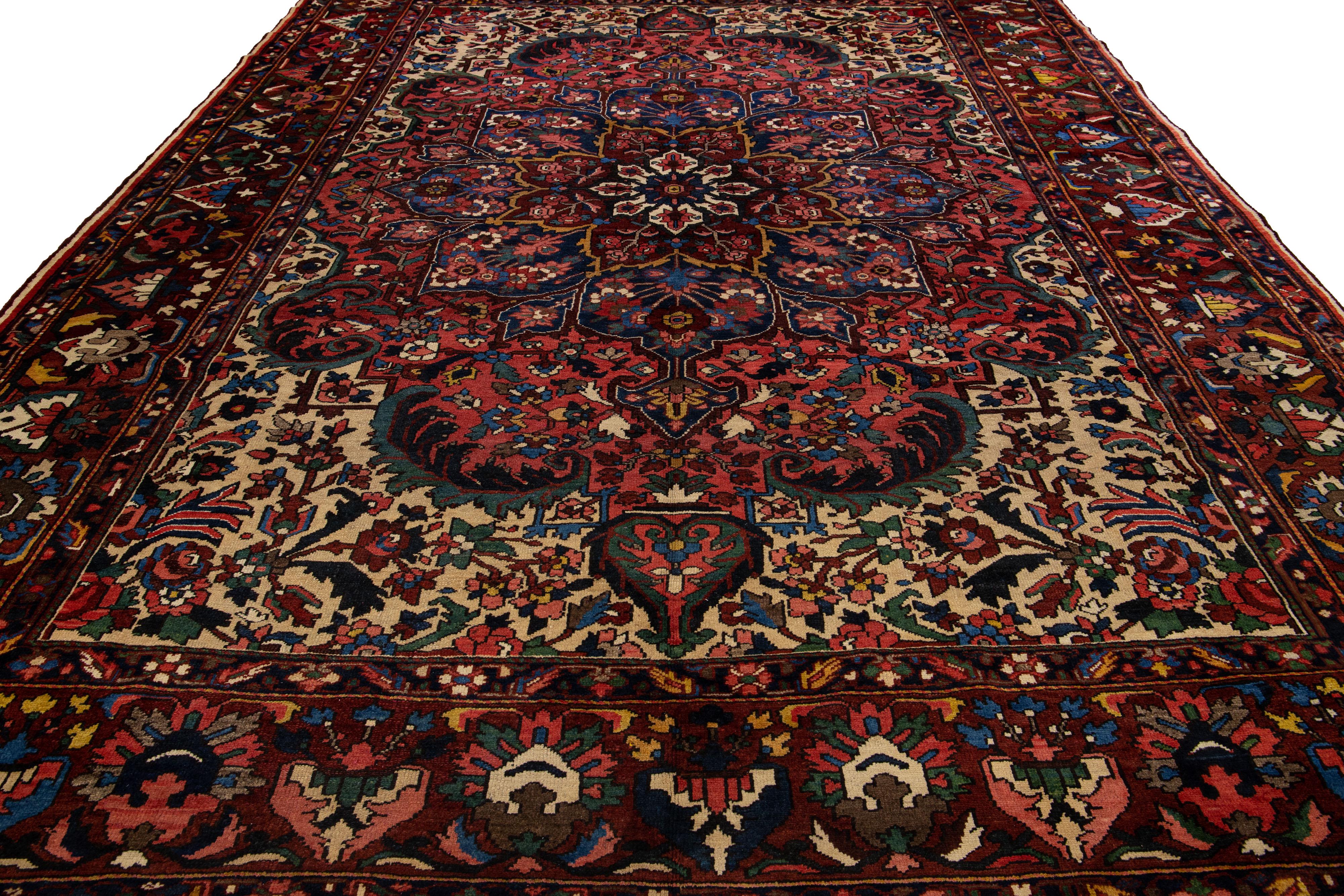Magnifique tapis ancien en laine Bakhtiari noué à la main avec un champ rouge. Cette pièce persane est ornée d'un accent multicolore dans un magnifique motif de rosette classique.

Ce tapis mesure 10'9