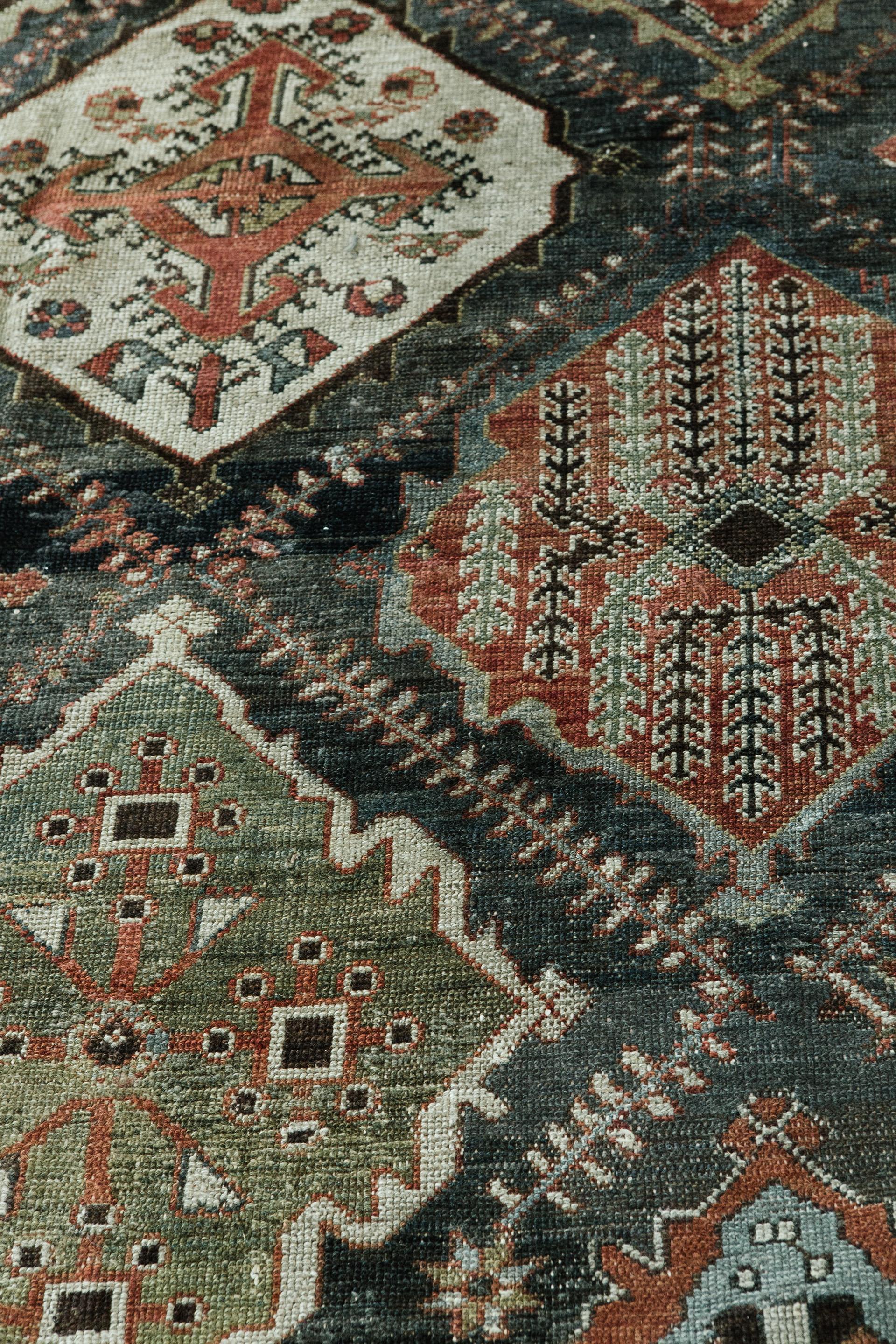 Cet ancien tapis persan Bakhitari a été conçu sur une grande échelle de stylisations géométriques aux tons profonds. Ces tapis ont été réalisés par des tisserands hautement qualifiés et ont nécessité environ six ans de travail dans les montagnes du
