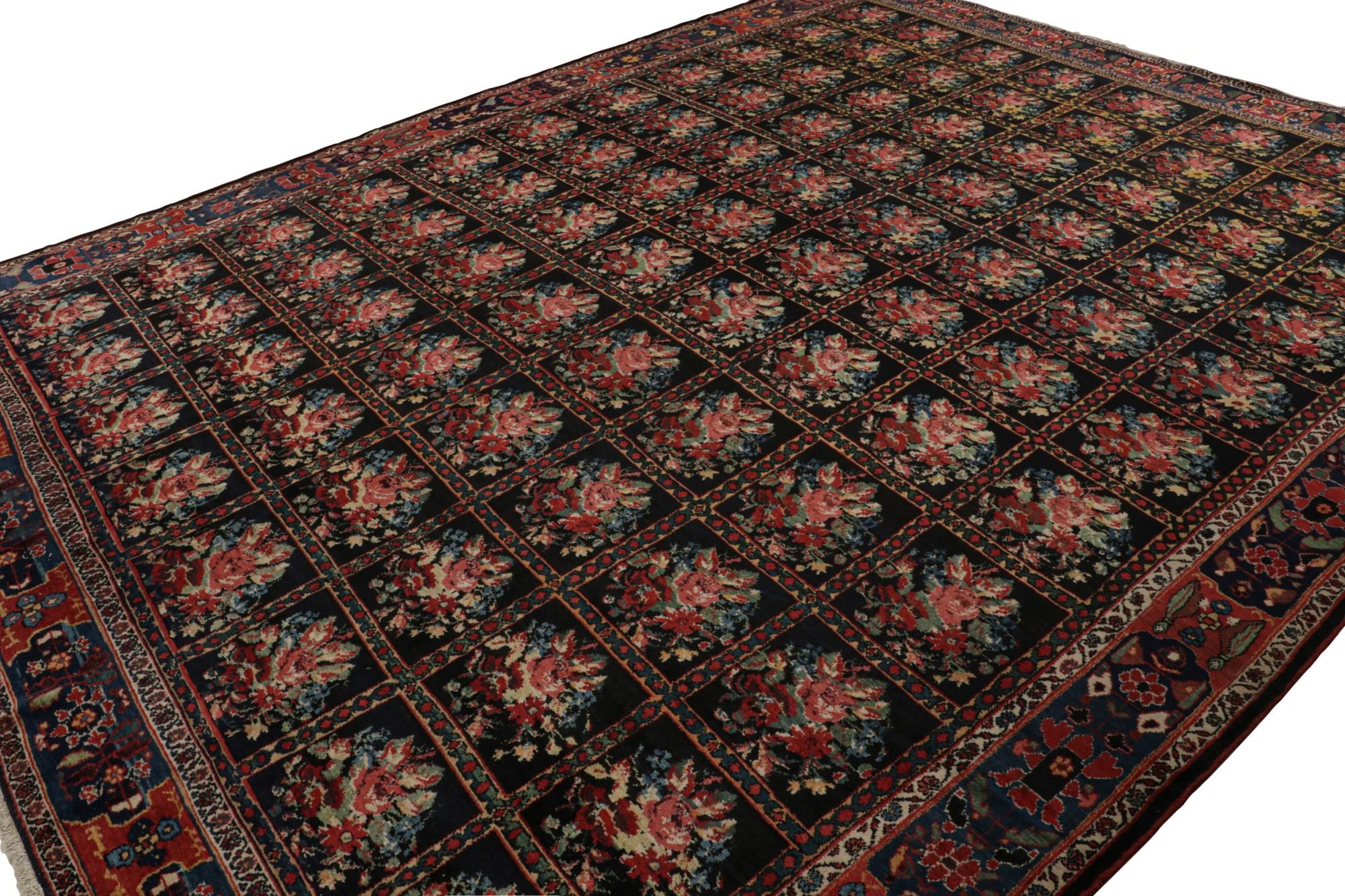 Hand-knotted with wool, originating circa 1920-1930, this 12x15 antique Persian Bakhtiari rug enjoys a rich black field with brown undertones, especially present red and gold in the many deep, saturated hues that depict its floral patterns. 

On the