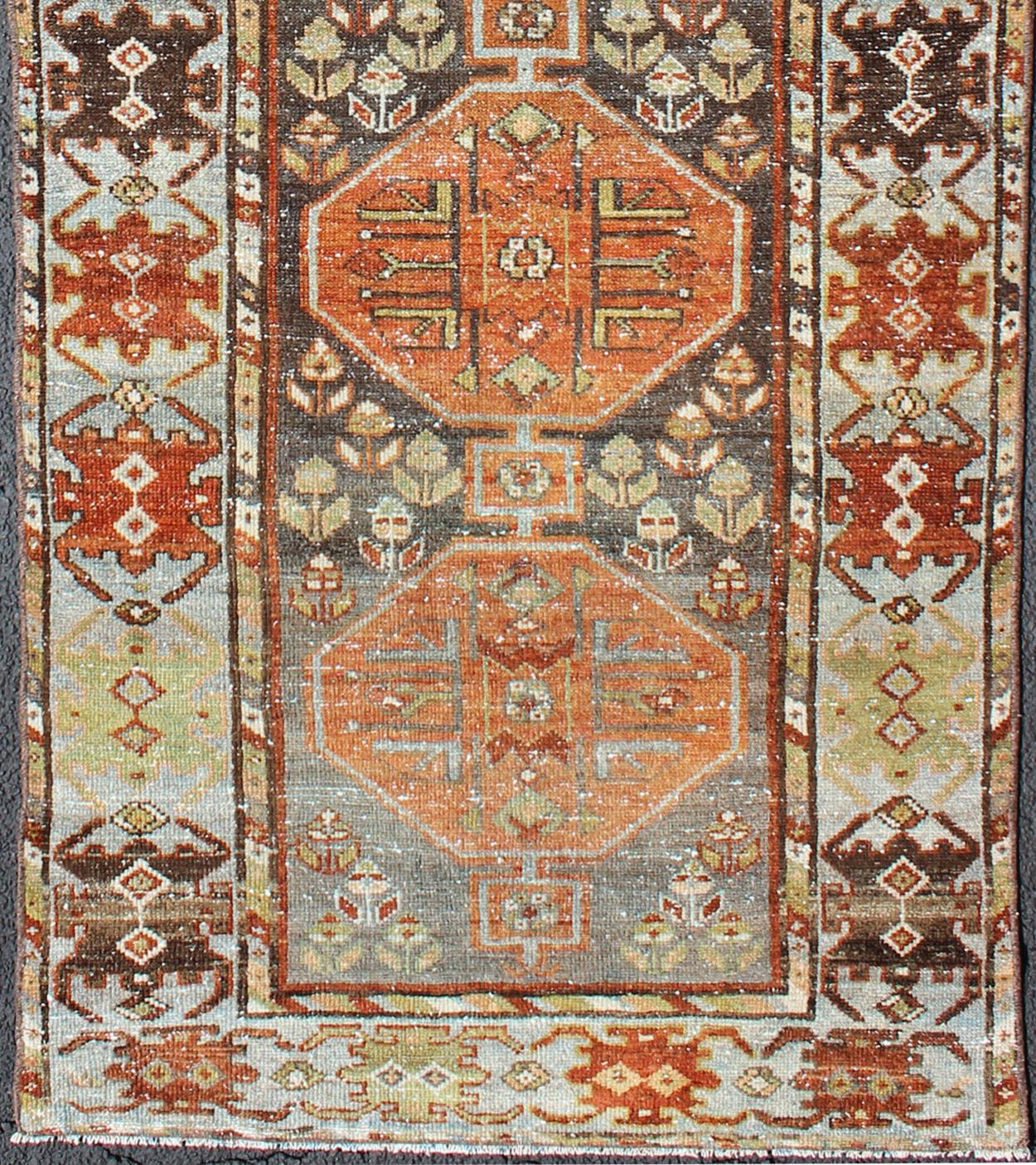 Bakhtiari antique runner from Persia with five geometric medallions in light blue, olive, orange, brown, and red, rug ema-7525, country of origin / type: Iran / Bakhtiari, circa 1910s.

This antique Persian Bakhtiari rug from early 20th century Iran