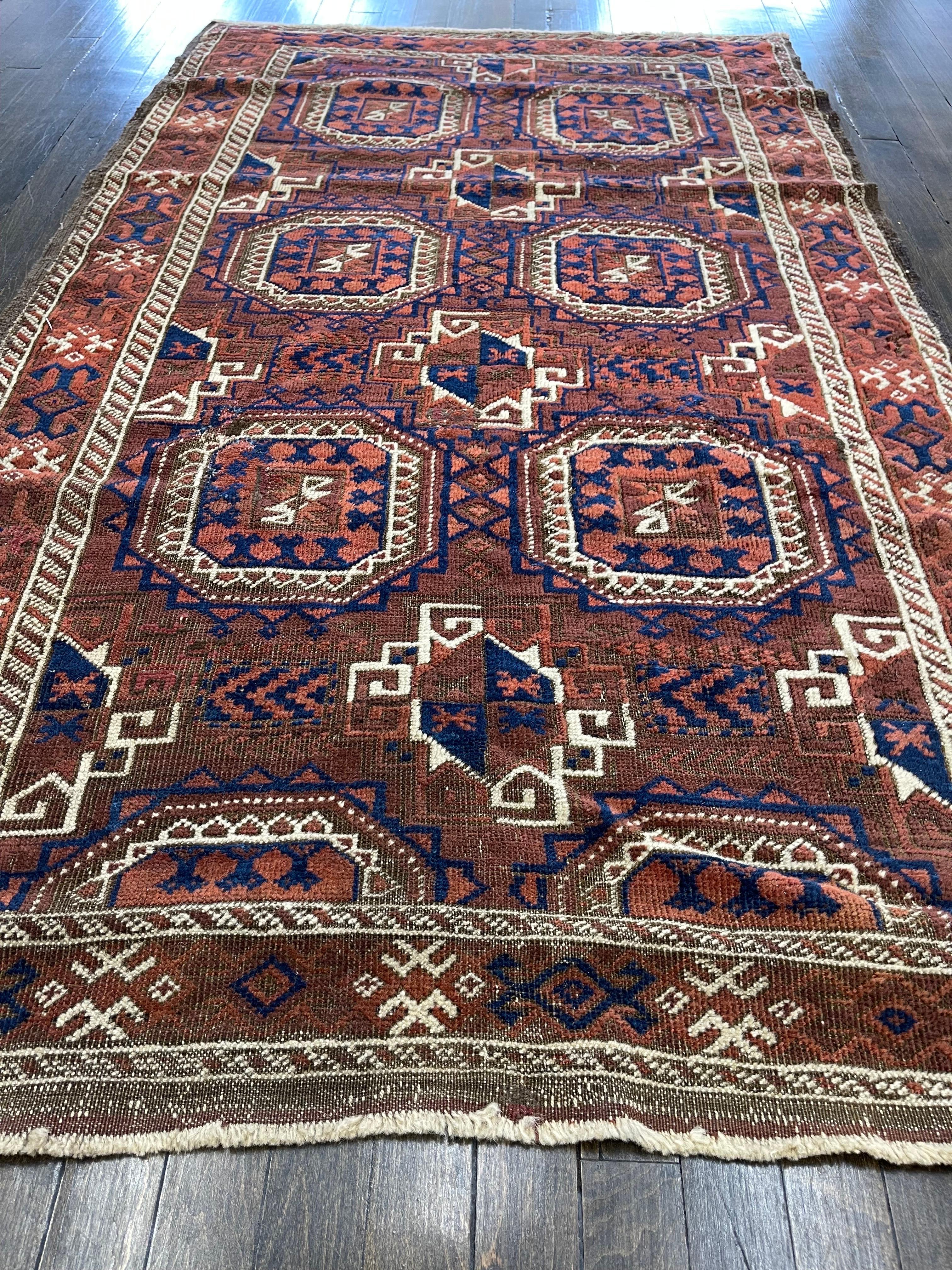 Having a rich brown field and incorporating electric blue balanced with lighter shades of brown and vivid ivory colors, this turn of the century Persian Baluch rug is decorated with six panel Gul resembling 