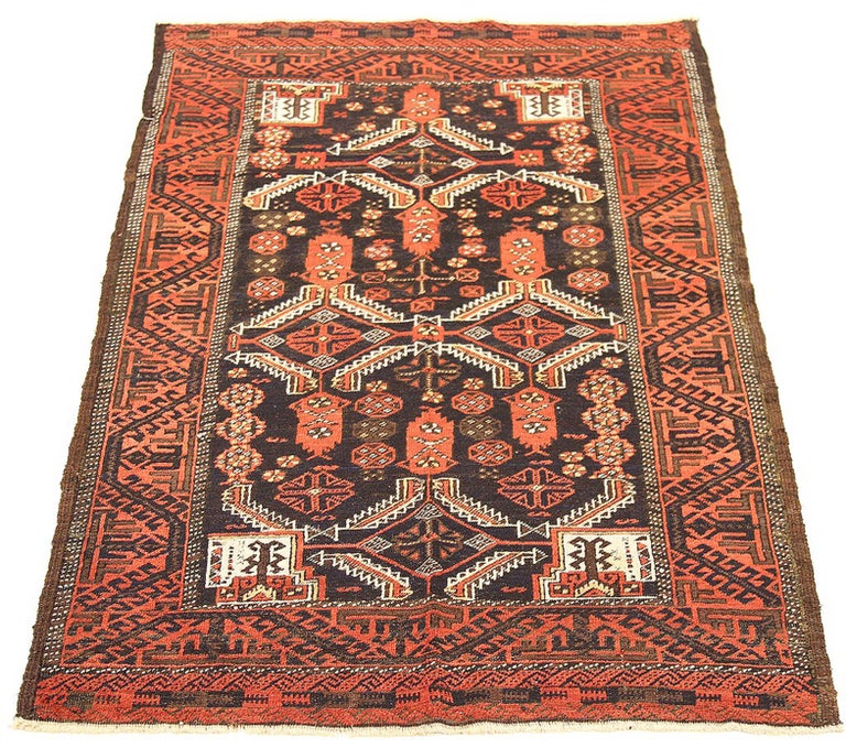 Antique Persian rug handwoven from the finest sheep’s wool and colored with all-natural vegetable dyes that are safe for humans and pets. It’s a traditional Baluch design featuring a mix of floral and geometric details in white and red over a black