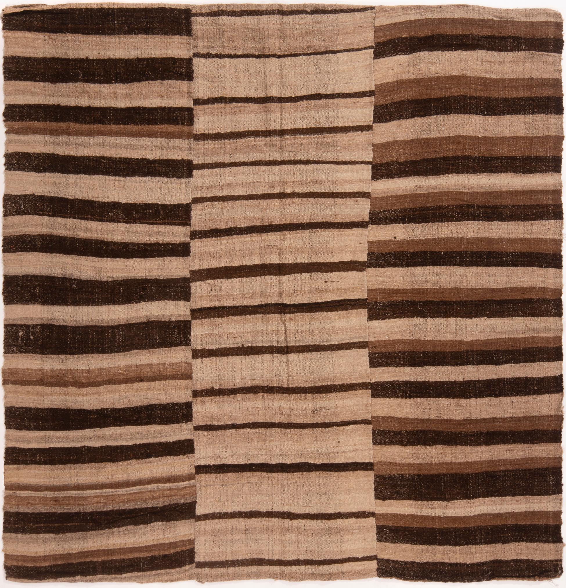 Originating from Persia in 1910, this antique wool Kilim rug is a unique ancestor to a family of rugs woven in vertical panels, each of the three with their own variation of a bold-yet-Minimalist geometric design. flat-woven in high quality wool