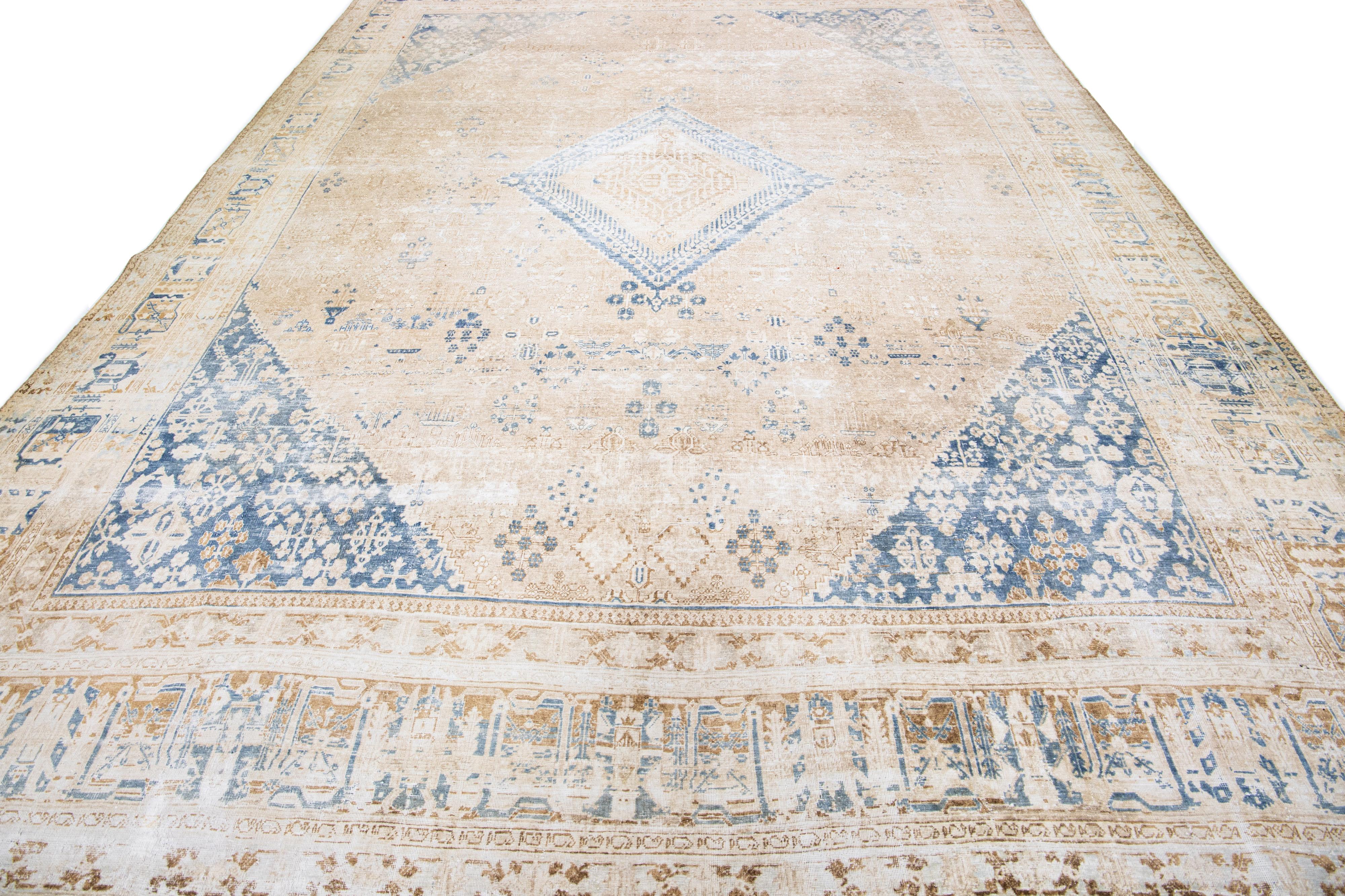 Magnifique tapis persan antique en laine nouée à la main, présentant un champ beige, encadré de beige avec des accents tan et bleu marine dans un motif de médaillon sur tout le pourtour.

Ce tapis mesure 10 x 14'6

Nos tapis sont nettoyés