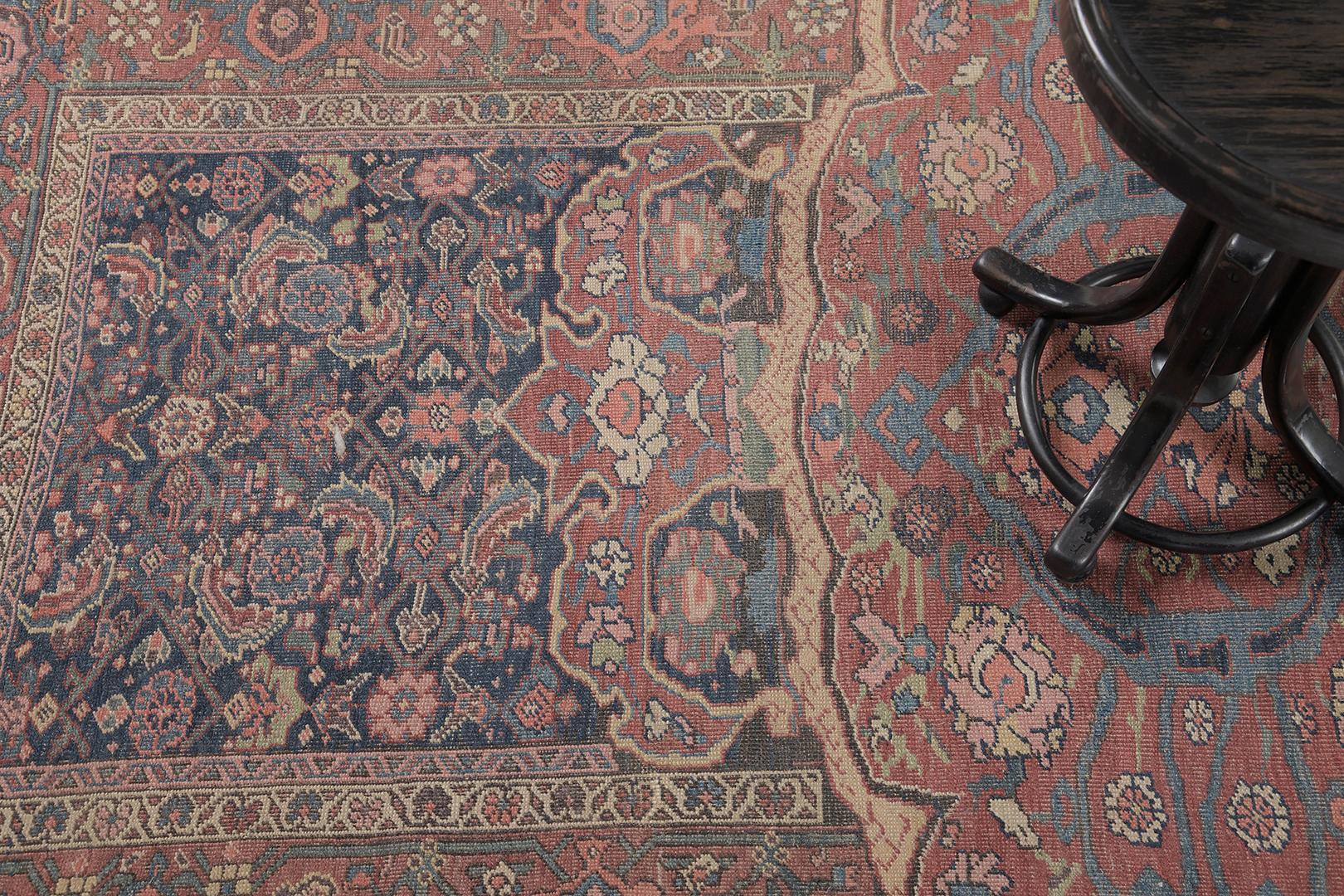 Un tapis persan ancien Bidjar fascinant qui présente divers éléments botaniques de palmettes luxuriantes, de motifs herati et de vignes sinueuses dans les magnifiques tons de bleu marine, de vieux rose et de beige. Ce tapis phénoménal charme sans