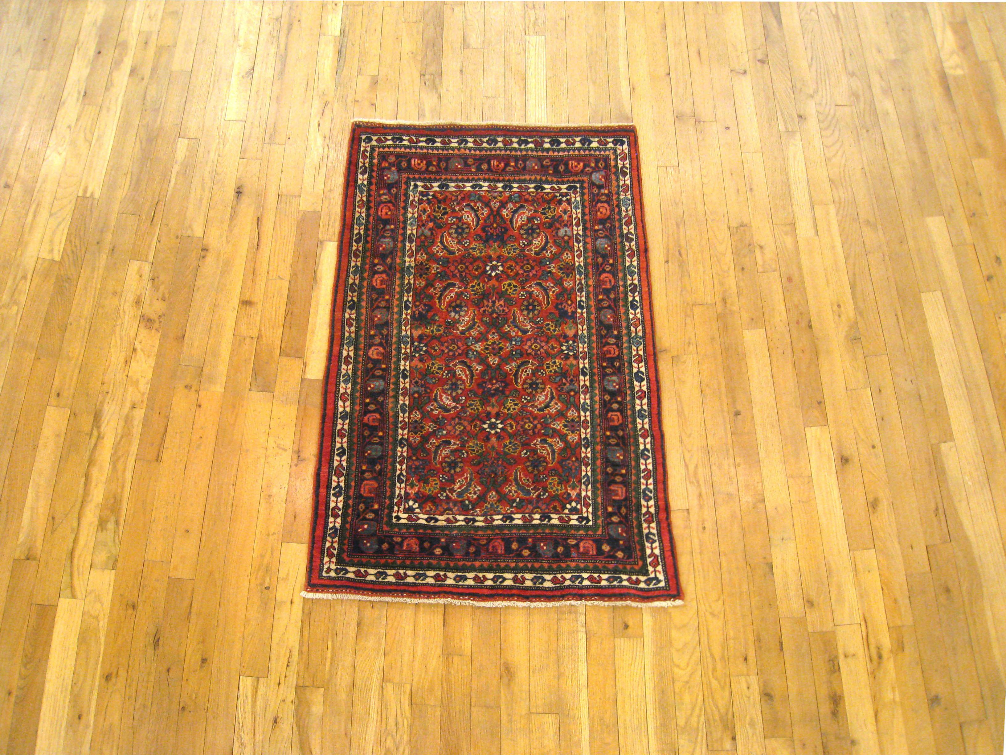 An antique Persian Bidjar oriental rug, size 4'1 x 2'7, circa 1920. This sturdy hand-knotted wool carpet features a stylized Herati design in the central plane, which is enclosed within a handsome dark blue primary border. This densely woven rug is