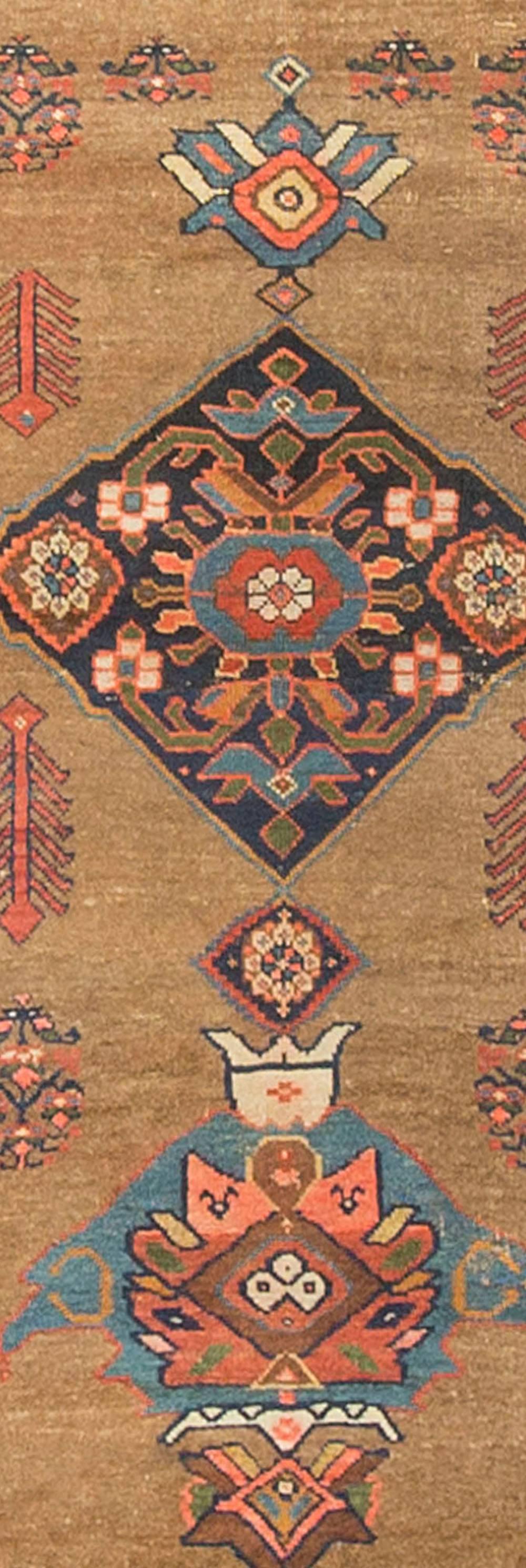 Un ancien tapis persan Bidjar datant des années 1920. Les couleurs sont utilisées intelligemment dans le dessin, les bleus clairs et les bleus foncés donnent un point focal et la bordure principale remplie de têtes de fleurs colorées complète le