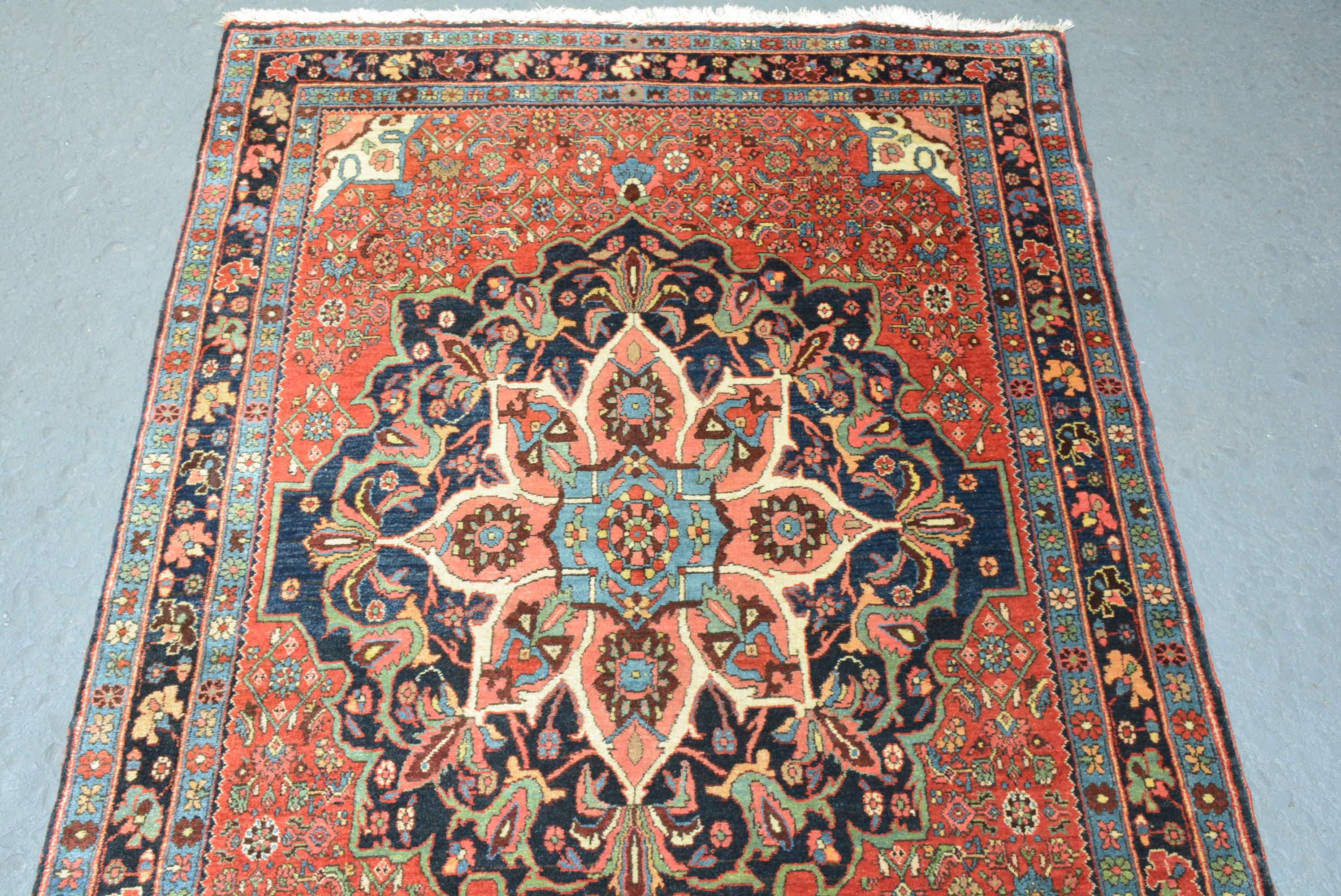 A Bidjar Rug from northern Persia, circa 1925 with a dramatic central floral medallion on a scarlet field measuring 5' 3