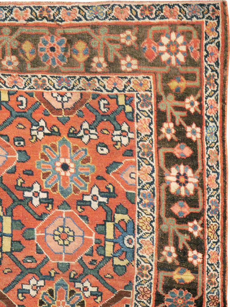 An antique Persian Bidjar rug. There are town Bidjars and village Bidjars, and this is one of the latter with a semi-geometric version of the Mina Khani palmette/rosette trellis, on an attractive rust orange ground. The dark brown border is a rustic