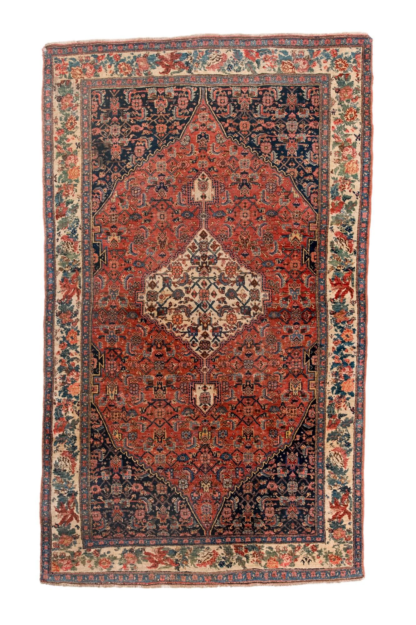 This antique Bidjar rug showcases a classic large medallion design with a red field, ivory center, and deep navy corners filled with tight floral motifs. The wide ivory border features scrolling blossoms and stylized foliage, giving the rug strong