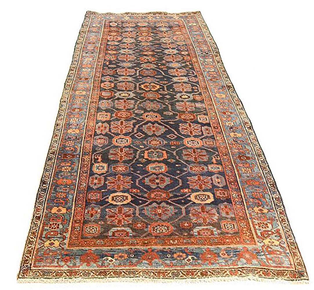 Antique Persian rug handwoven from the finest sheep’s wool and colored with all-natural vegetable dyes that are safe for humans and pets. It’s a traditional Bijar design featuring lovely colors of red, navy and blue. It has all-over rows of floral