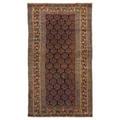 Tapis persan Bijar ancien avec médaillons rouges et verts sur fond bleu marine
