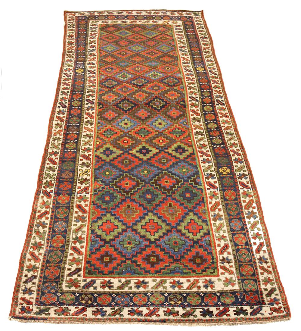 Antique Persian runner rug handwoven from the finest sheep’s wool and colored with all-natural vegetable dyes that are safe for humans and pets. It’s a traditional Bijar design featuring floral details in blue and green over an ivory field. It’s a
