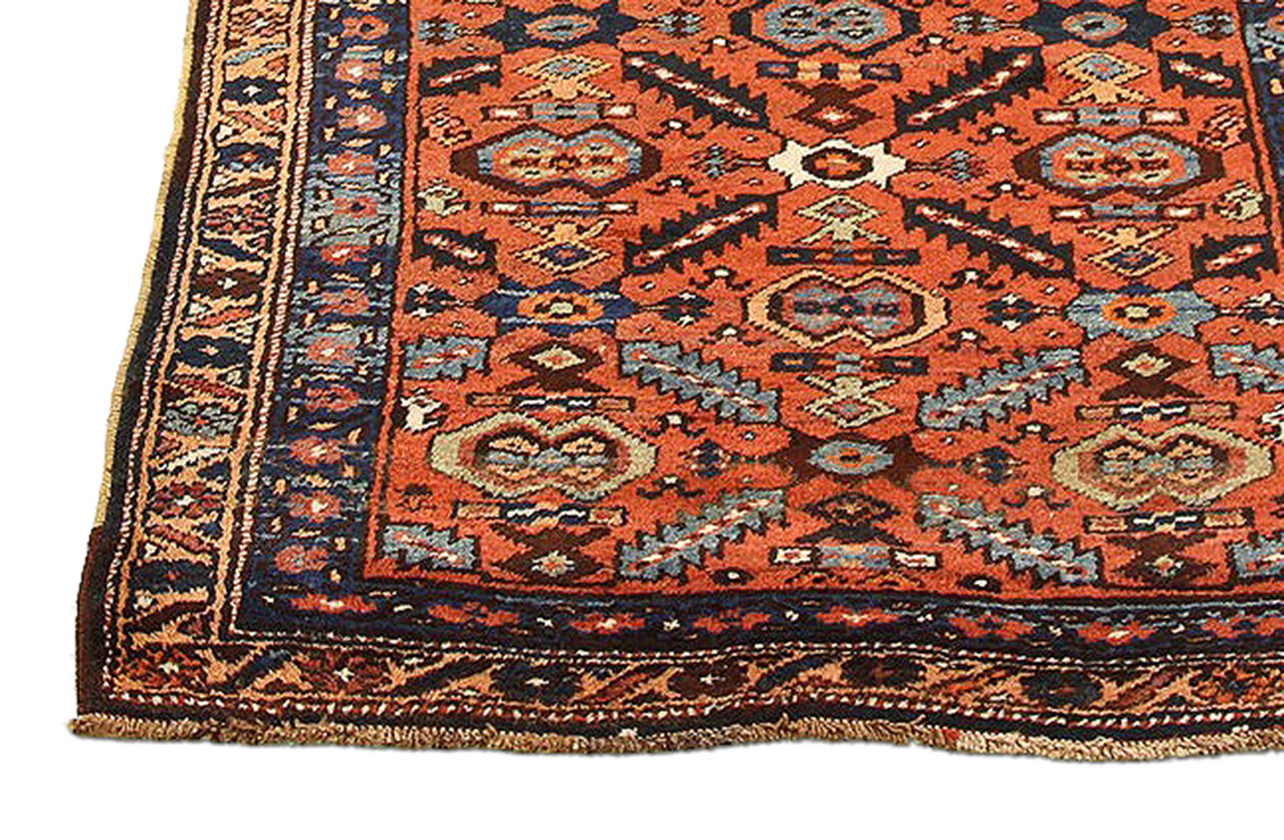 Antique Persian runner rug handwoven from the finest sheep’s wool and colored with all-natural vegetable dyes that are safe for humans and pets. It’s a traditional Bijar design featuring blue, navy, and white flower medallion details over a red
