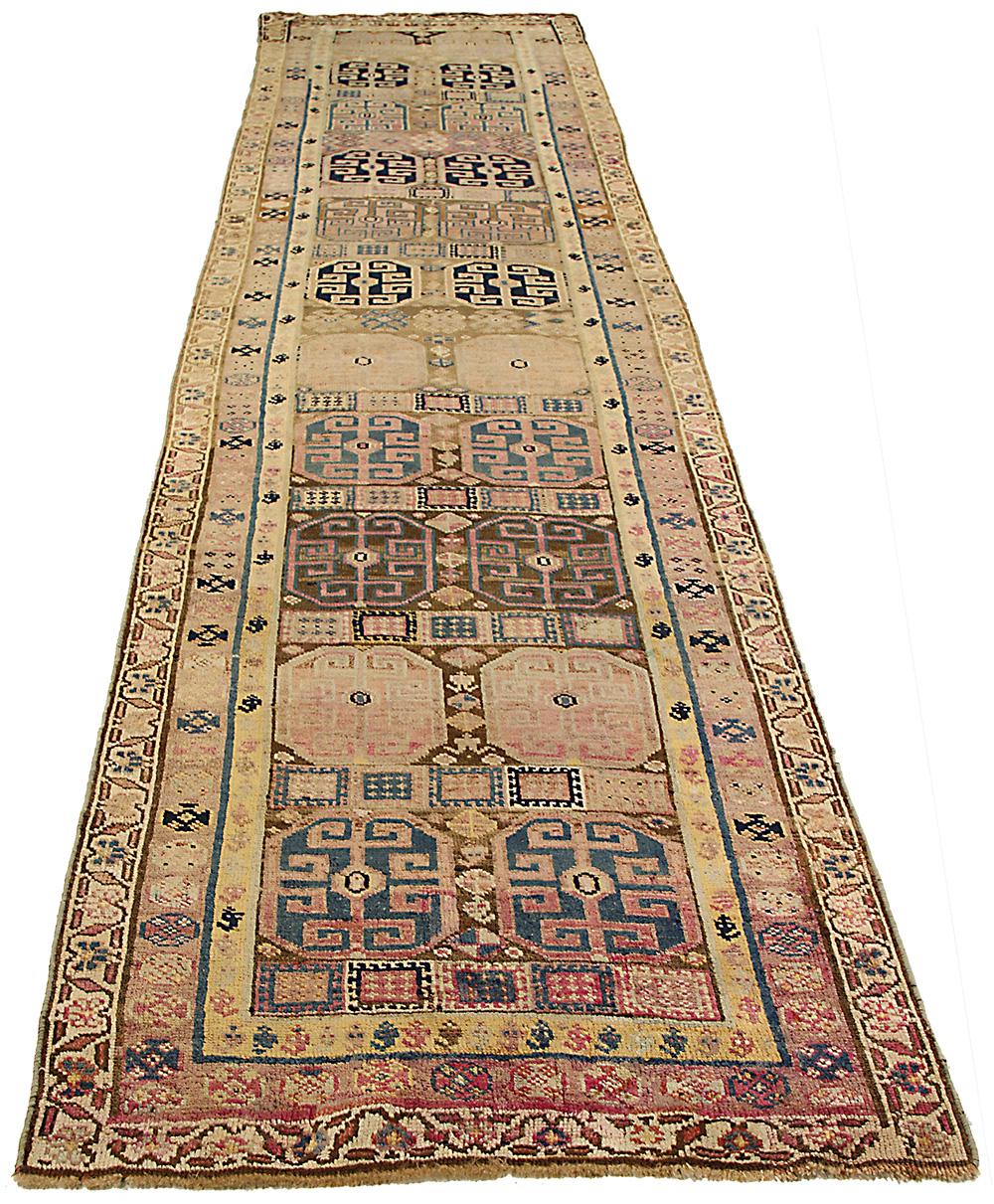 This antique Persian runner rug is a masterpiece of craftsmanship, handwoven from the finest sheep’s wool and colored with all-natural vegetable dyes that are safe for humans and pets. Featuring a traditional Bijar design with geometric and