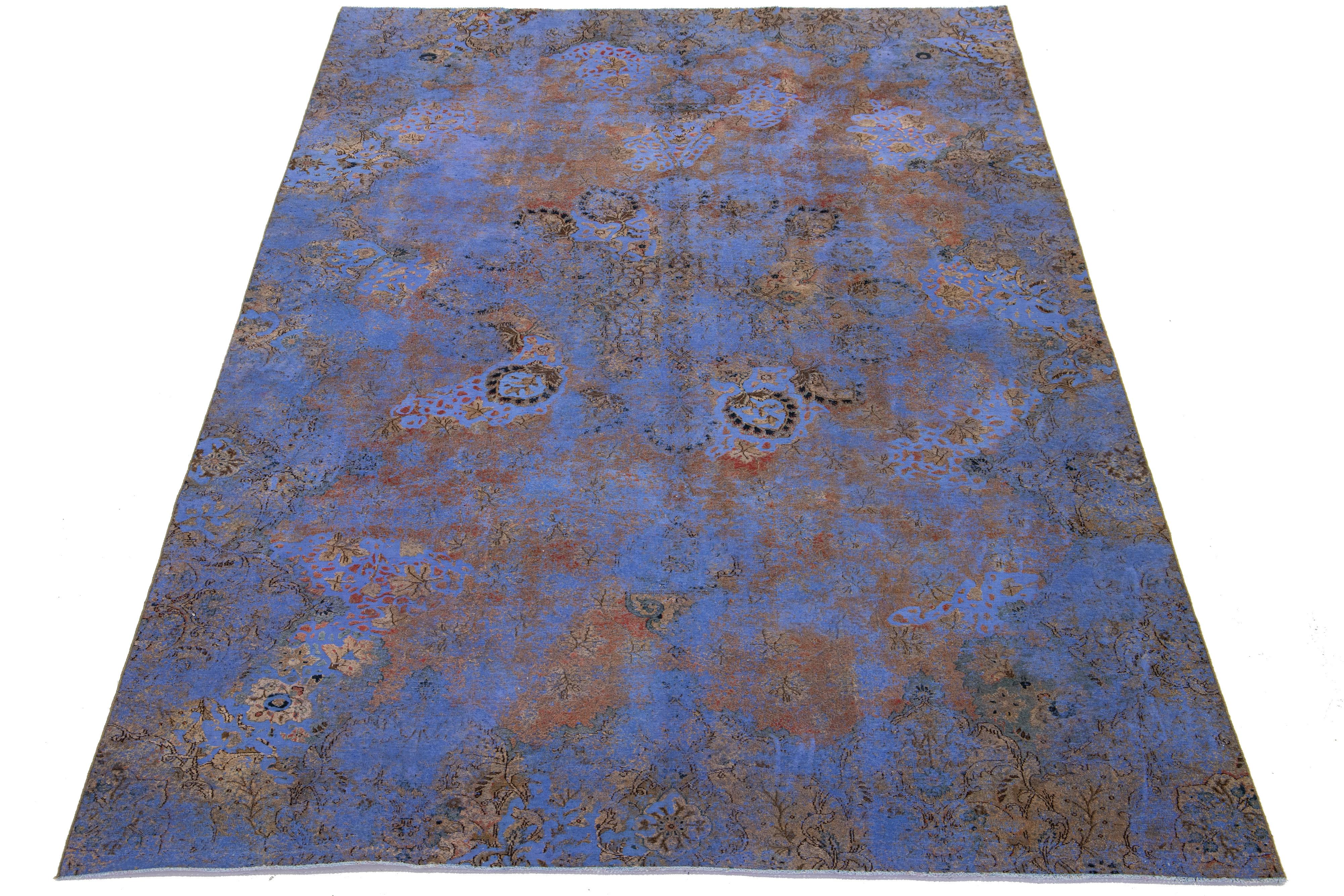 Ce tapis persan en laine bleu antique présente un motif floral aux accents beige, rouille et marron.

Ce tapis mesure 7'5'' x 12'5
