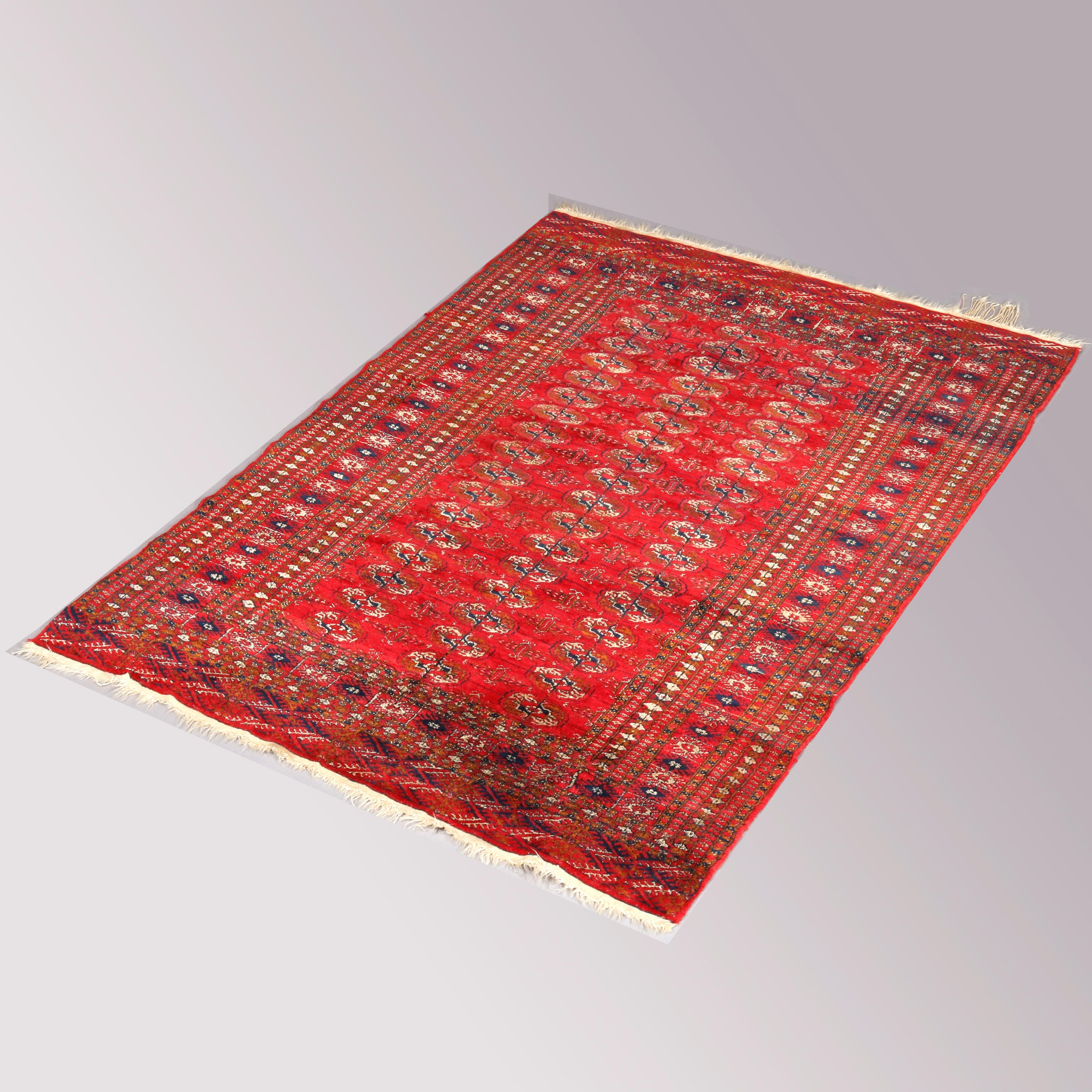 An antique Persian Bokhara nomadic tribal Oriental rug offers wool construction with all-over geometric pattern on red ground, circa 1920

Measures: 73