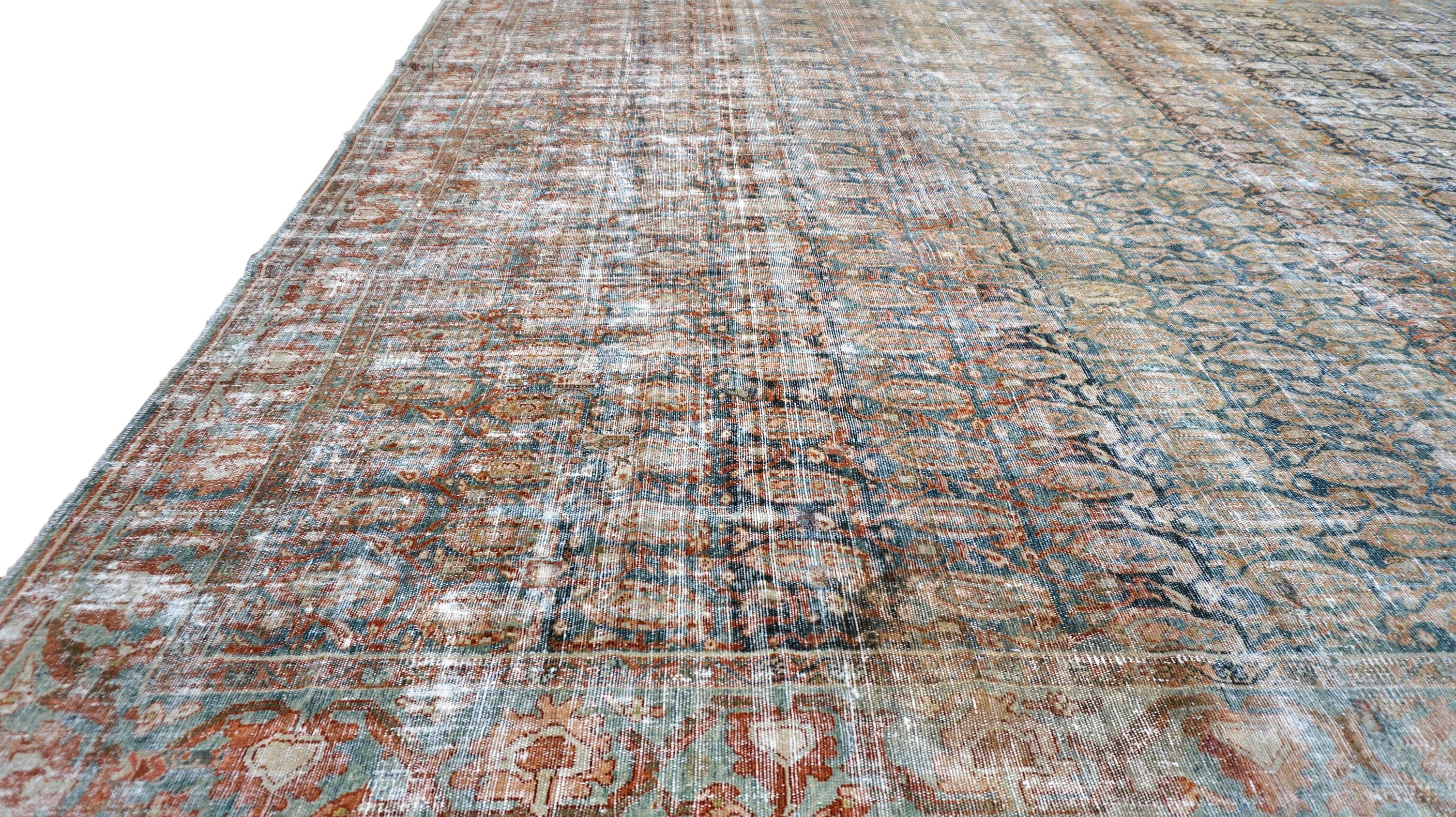 This exquisite Antique hand-knotted wool rug is a stunning example of traditional craftsmanship blended with a beautifully distressed aesthetic. Featuring a richly detailed repeating medallion motif throughout, the design showcases fine artistry