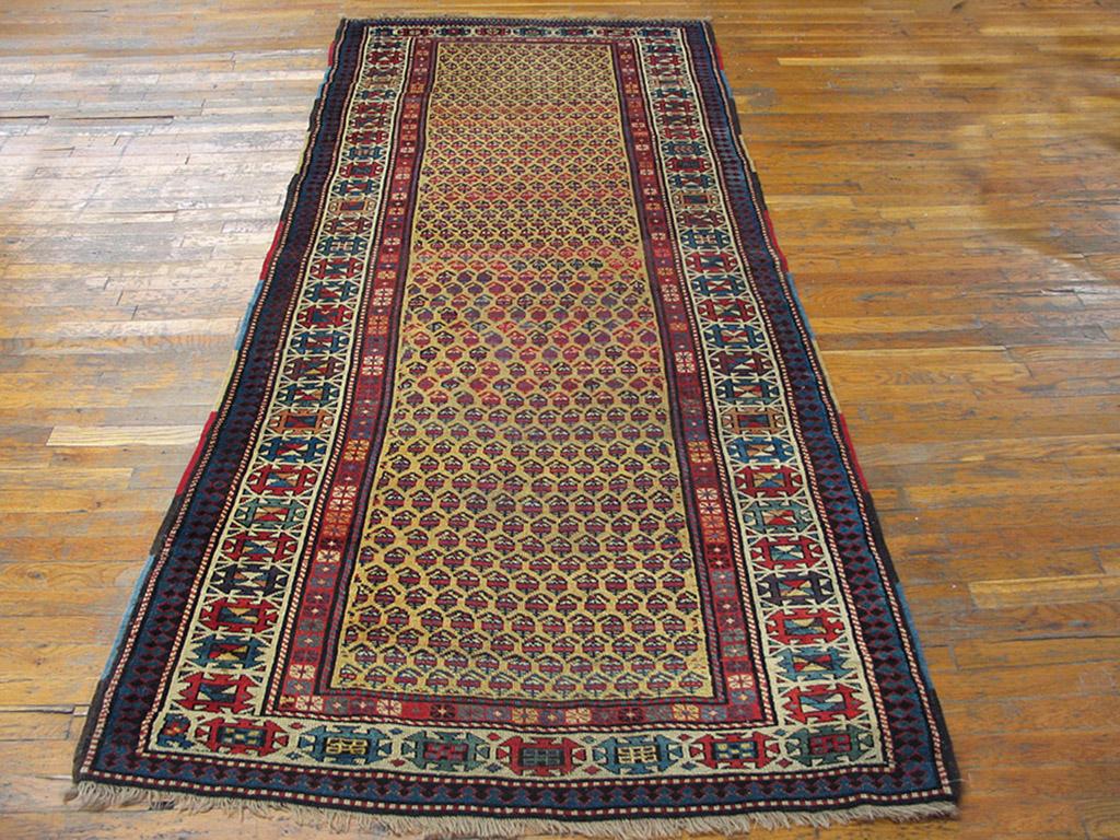 Untold thousands of tiny botehs swim on the mustard yellow field of this unusual southeast Caucasian carpet. There are no other elements to interrupt their movement in this c. 1880 rug.The ivory main border employs squared-off medallions inside the