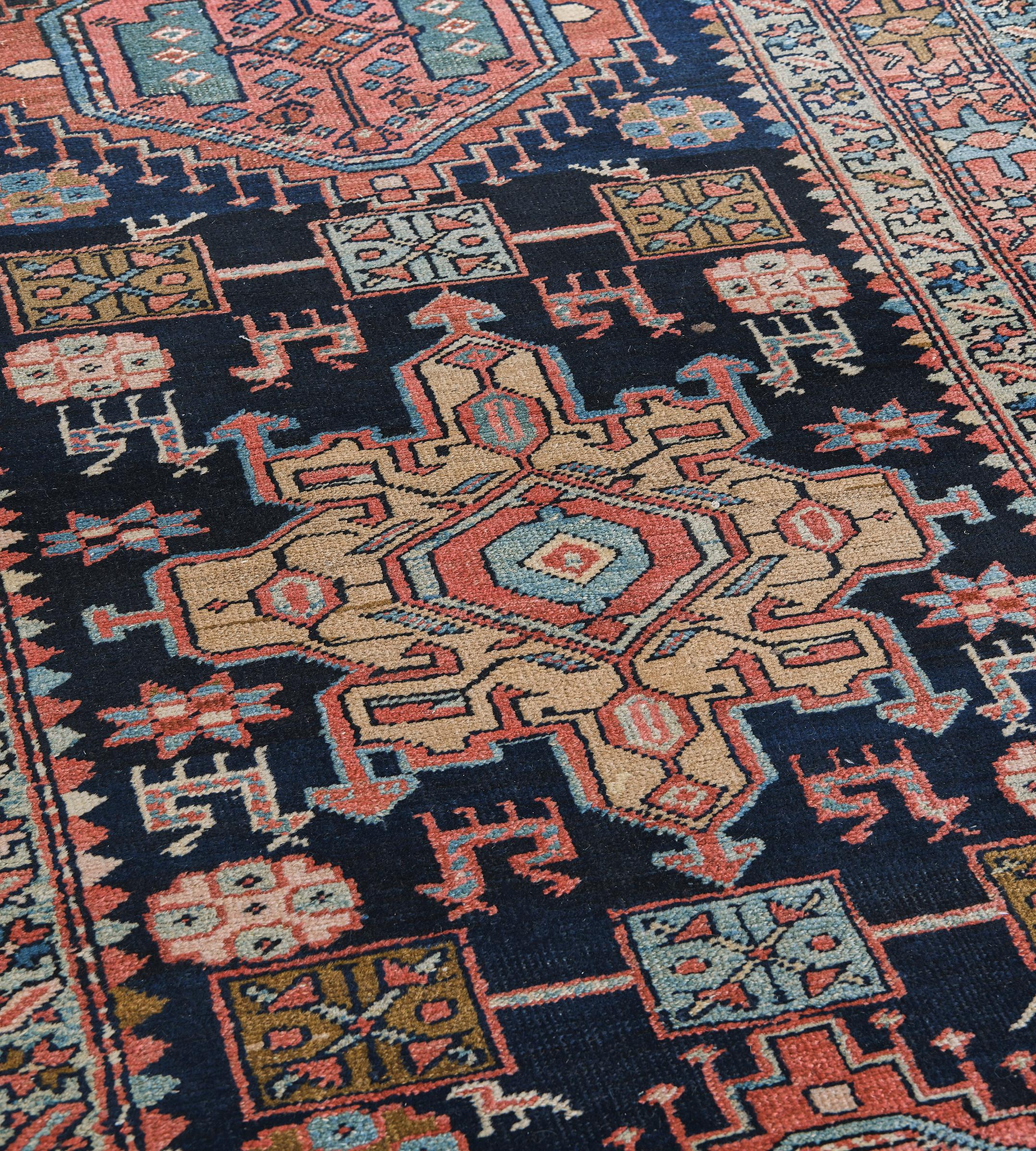 Dieser antike persische Heriz-Läufer hat ein tief indigoblaues Feld mit einer zentralen Säule aus polychromen hellblauen, ziegelroten und sandgelben Stufen- und Hakenrauten, die jeweils eine zentrale Raute und eine Vielzahl von eckigen floralen