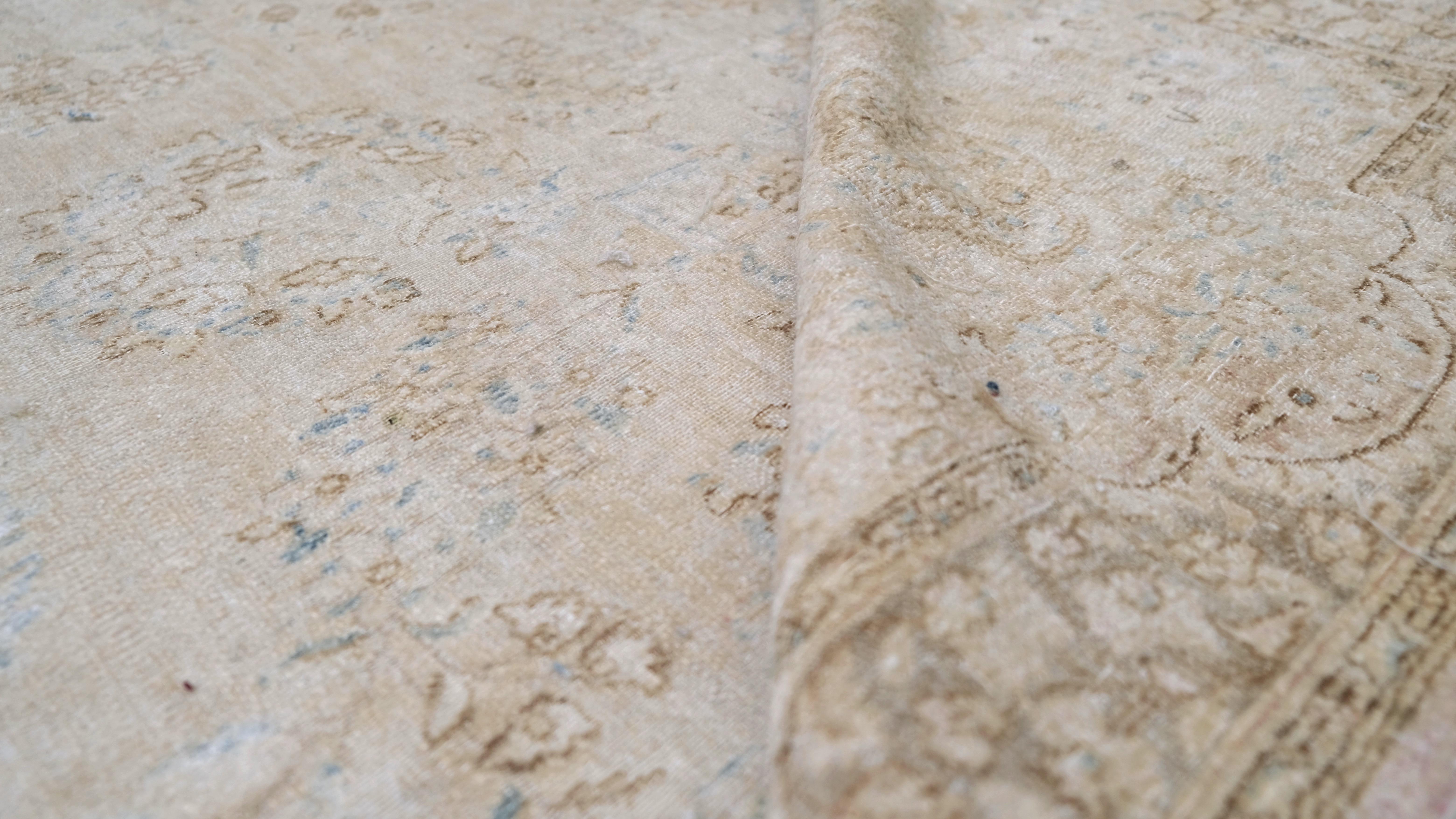 Questo elegante tappeto antico in lana annodato a mano è un esempio magistrale di artigianato senza tempo. Caratterizzato da un delicato disegno floreale all-over, questo tappeto è reso in una tavolozza tenue di crema, beige e tenui accenti