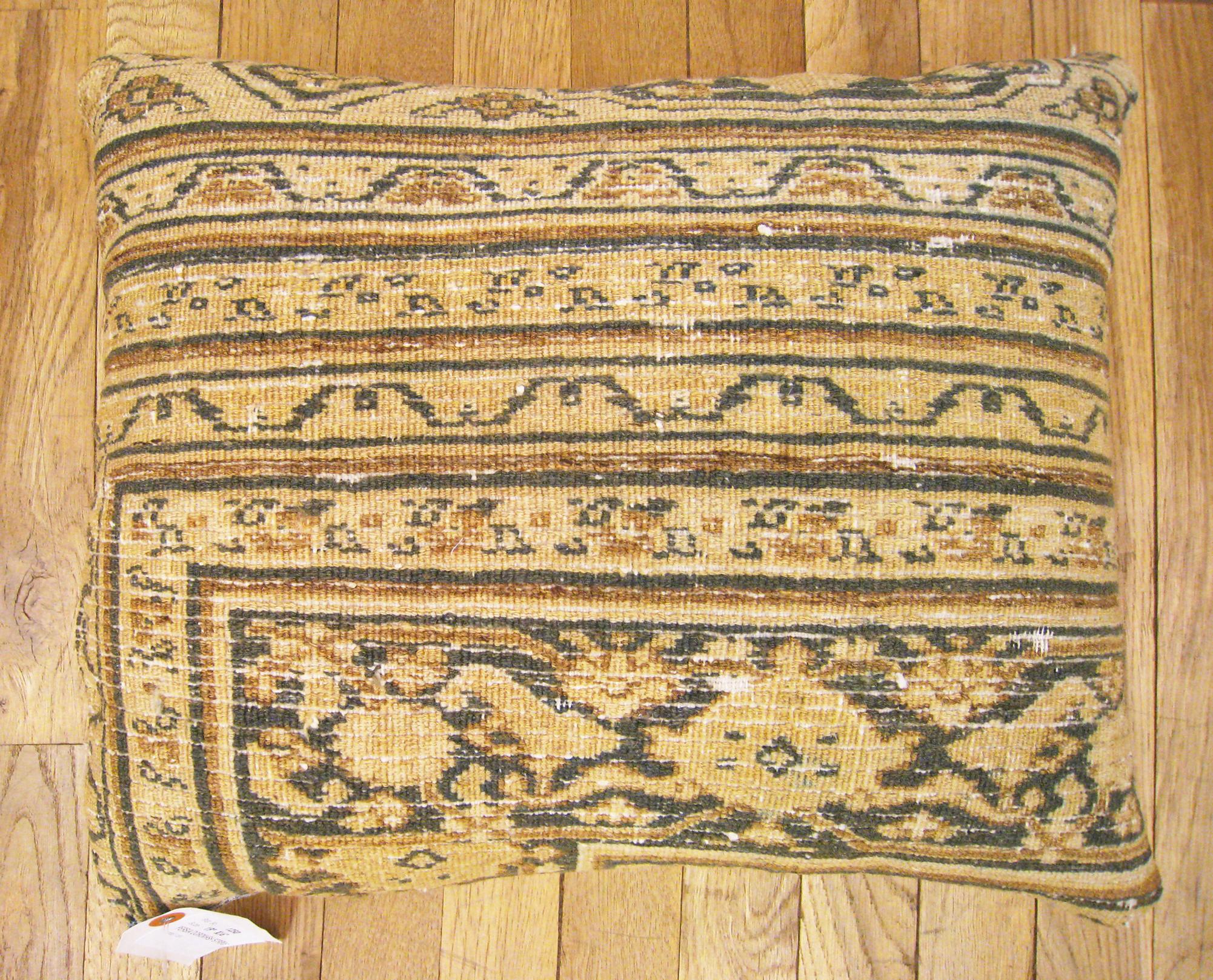 A lovely decorative pillow fronted by a segment of an antique Persian Dorokhsh carpet, and backed with an ivory colored striped fabric, in the size 19