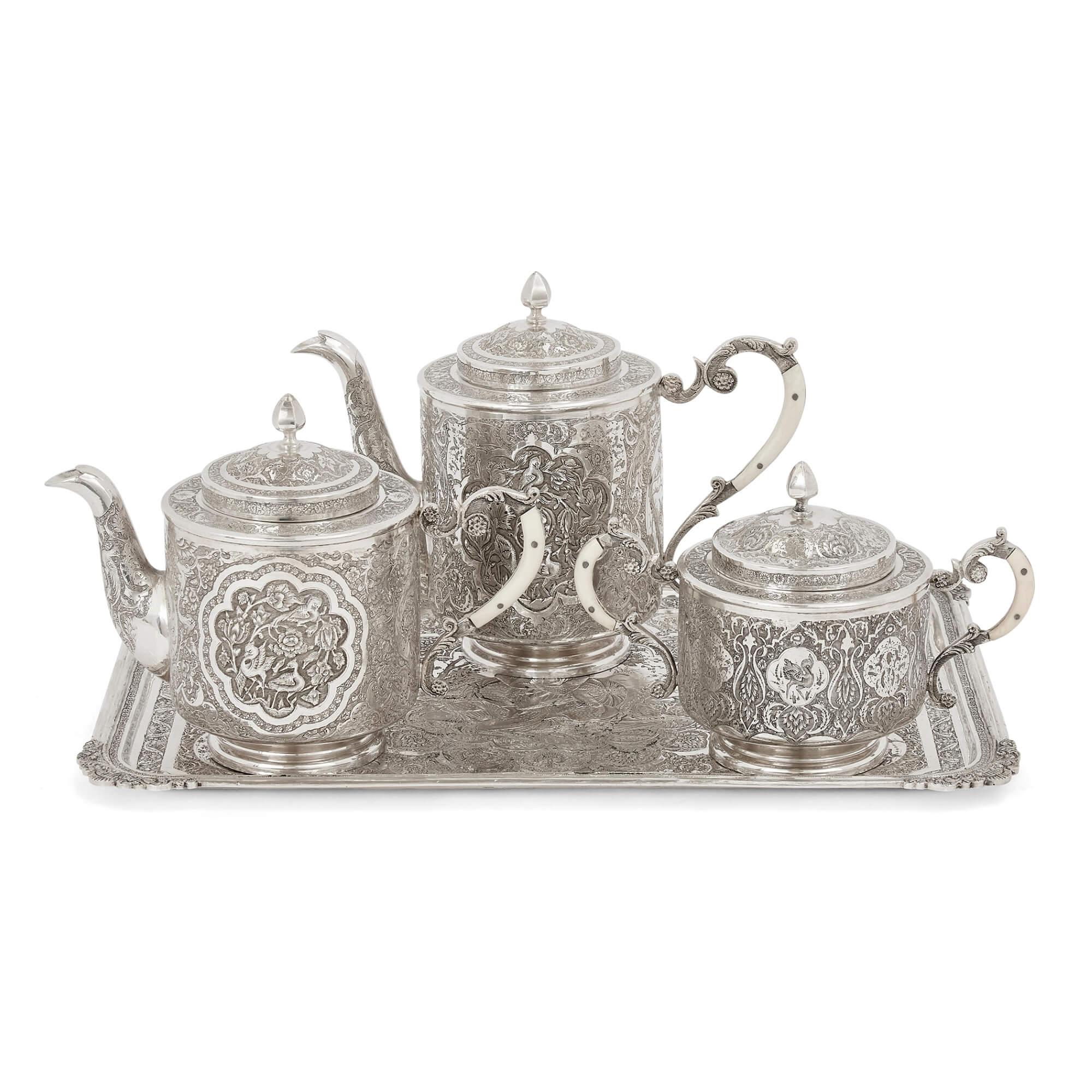 Antique Persian engraved silver tea service
Persian, early 20th century
Measures: Tray: Height 1.5cm, width 38.5cm, depth 27cm
Teapot: Height 17cm, width 23cm, depth 11cm

This elegant silver tea and coffee service is designed in a distinctive