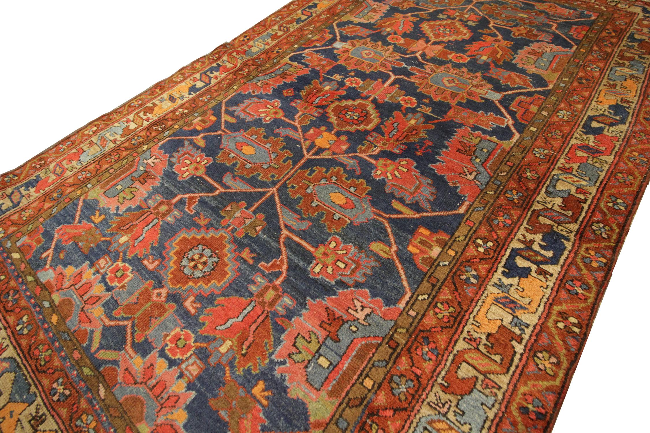 This antique Farhan carpet rug was handwoven with beautiful red and blue colourways. This rug features a floral tribal motif symmetrical design. The deep blue background contrasts beautifully with the interweaving red design to create an