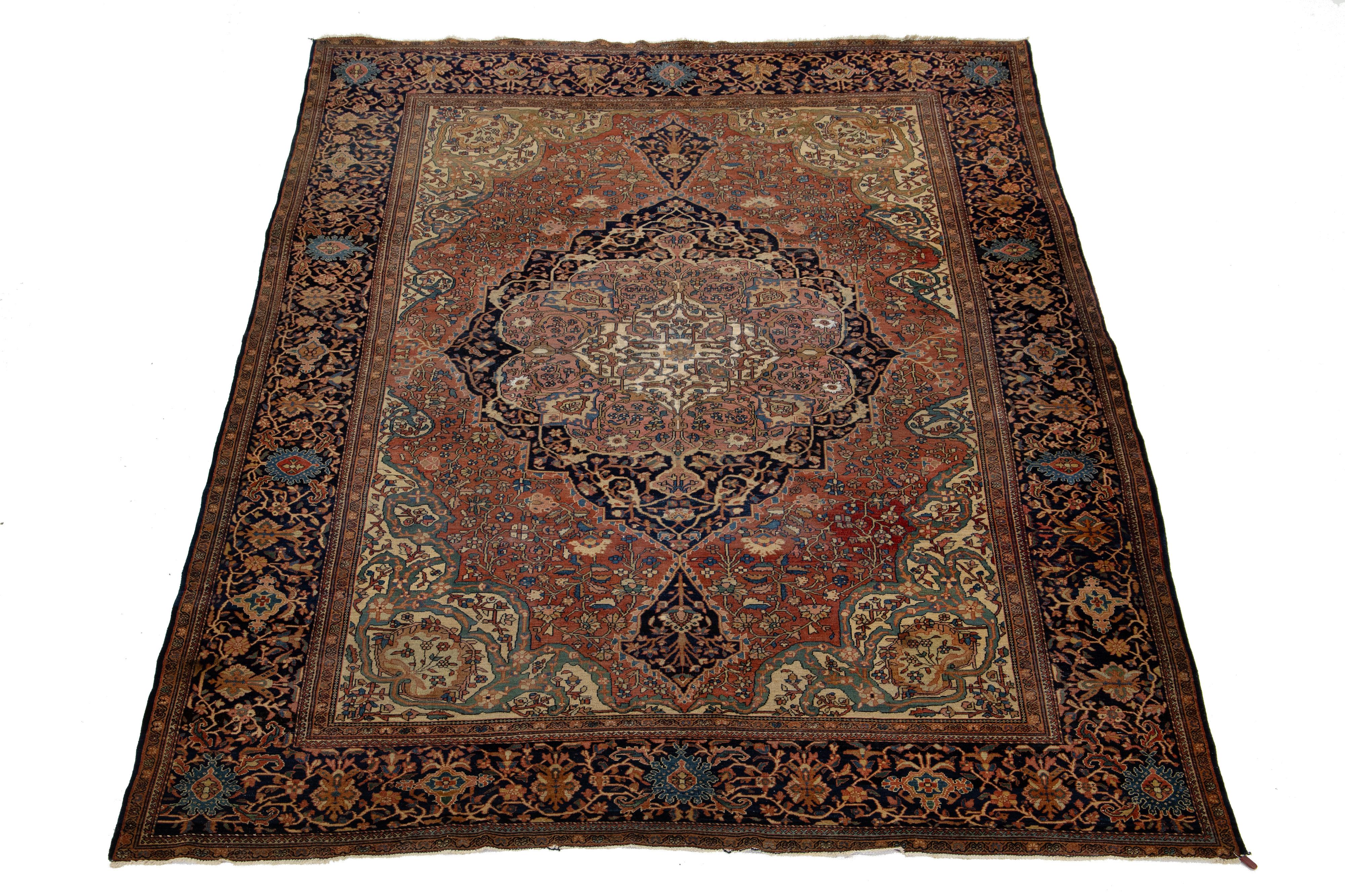 Ce magnifique tapis Sarouk Farahan en laine nouée à la main présente un champ de couleurs bleu marine et rouille. Il est encadré d'accents multicolores et présente un motif floral médaillon classique.

Ce tapis mesure 8'3