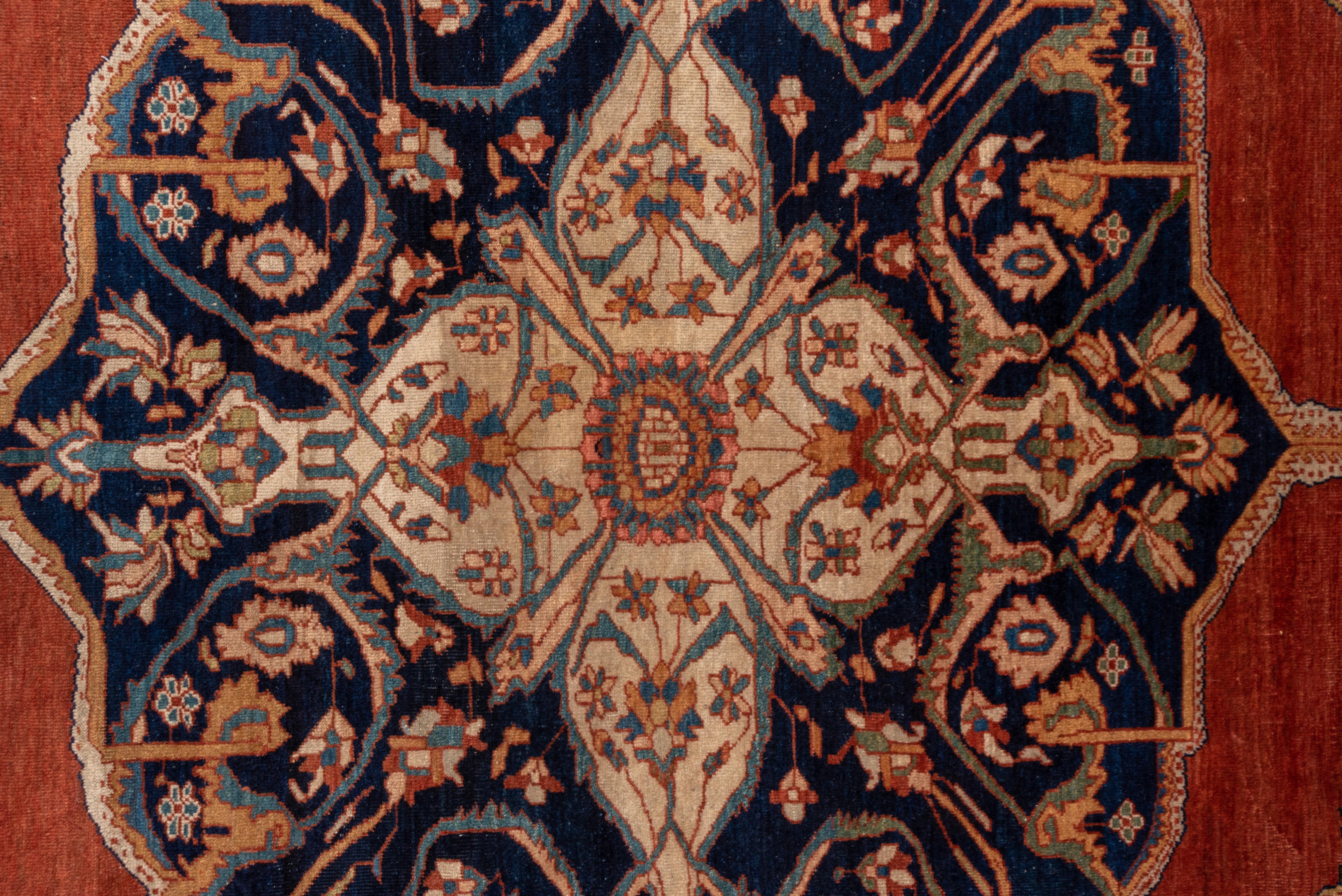 This fine Persian carpet has a warm madder red field is centered by a squarish navy octogramme medallion with doubled pendants and set off by octofoil star corners. Navy palmette and forked arabesque main border. Excellent natural dyes, Fine drawing