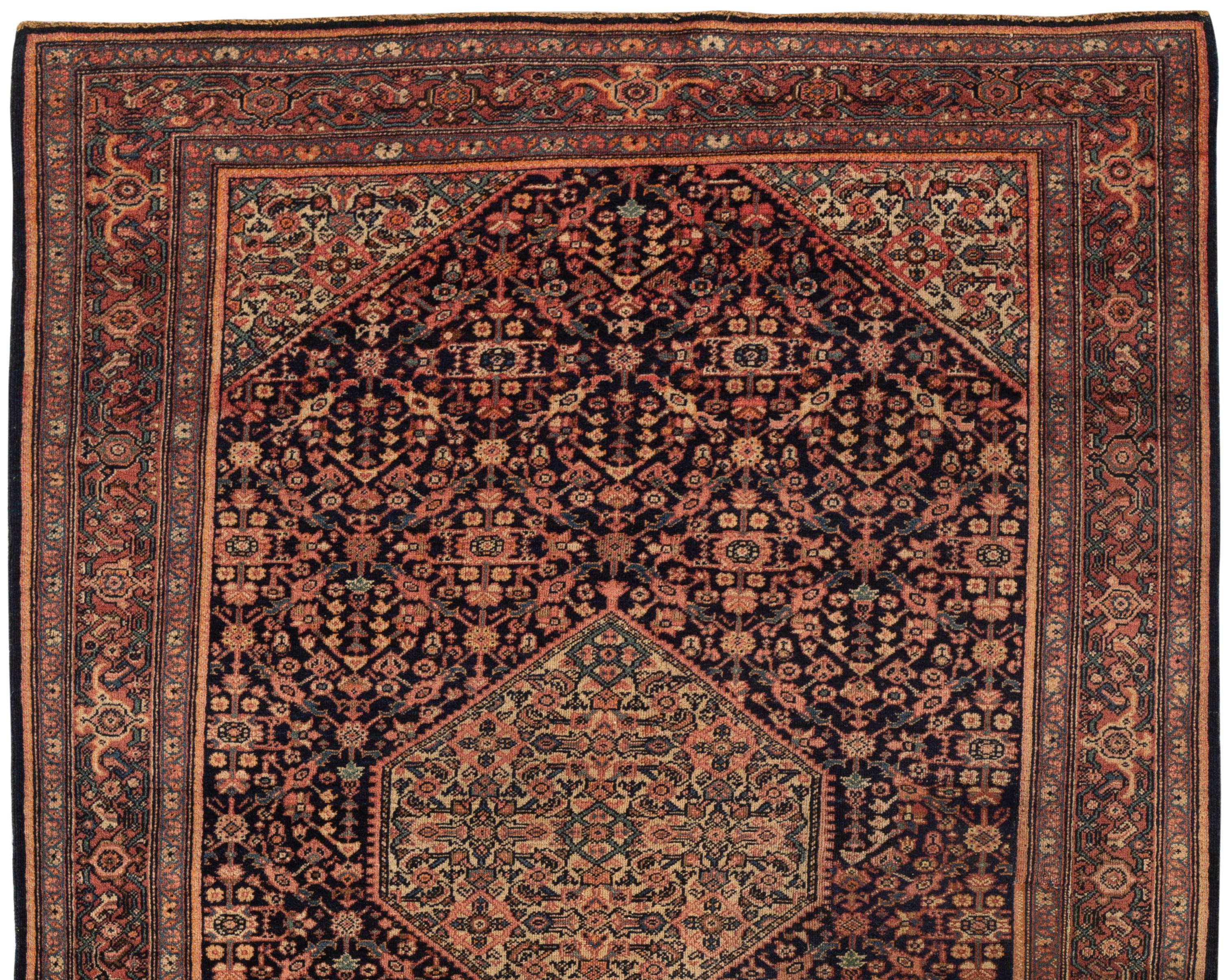 Tapis sarouk persan ancien de Farahan vers 1900. Ce charmant tapis est plein de détails merveilleux et montre la véritable compétence du tisserand pour créer ce petit chef-d'œuvre. Le champ marine profond est complété par une bordure légèrement plus