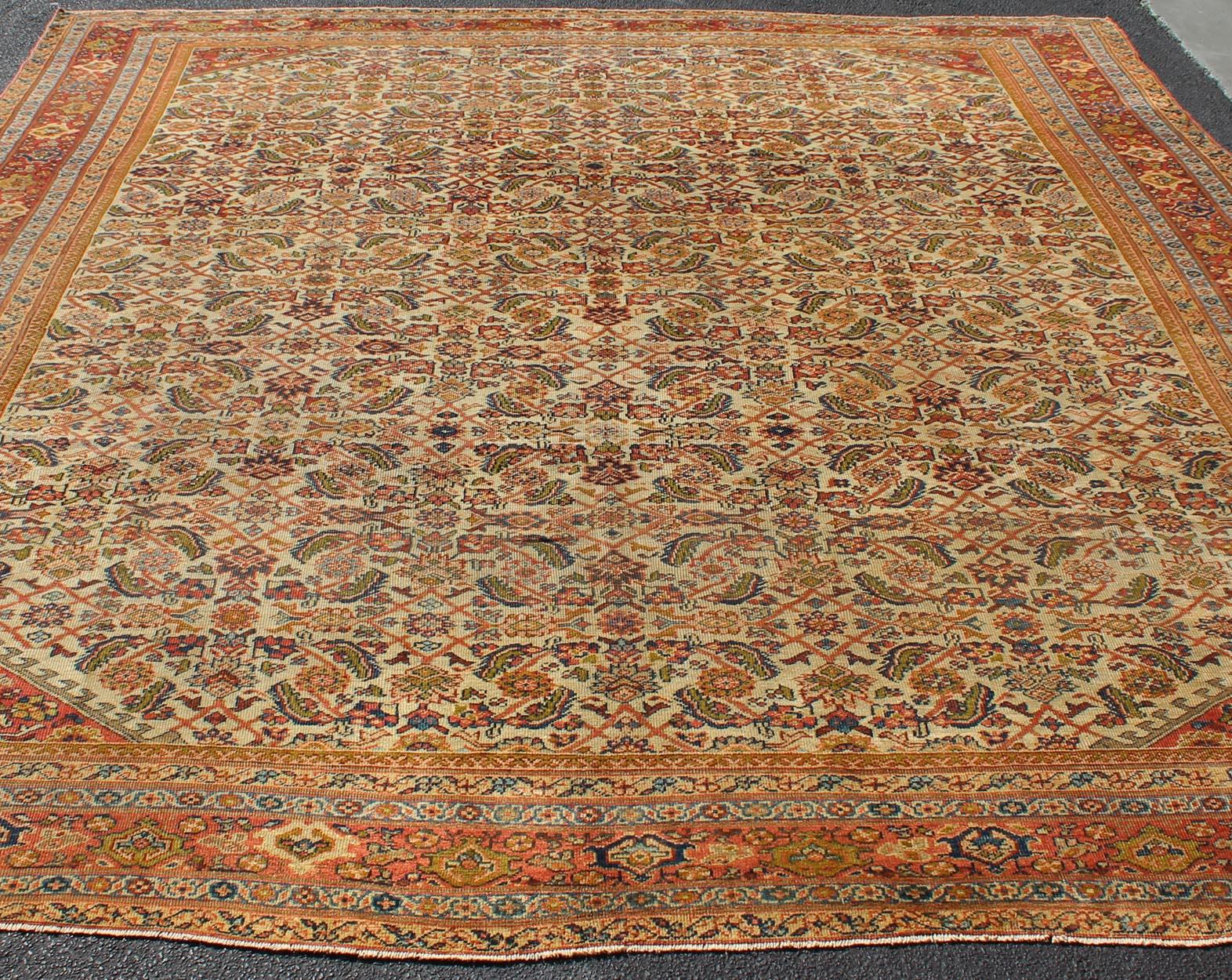 Alfombra persa antigua Ferahan con diseño Herati integral en marfil, coral y verde Anudado a mano en venta