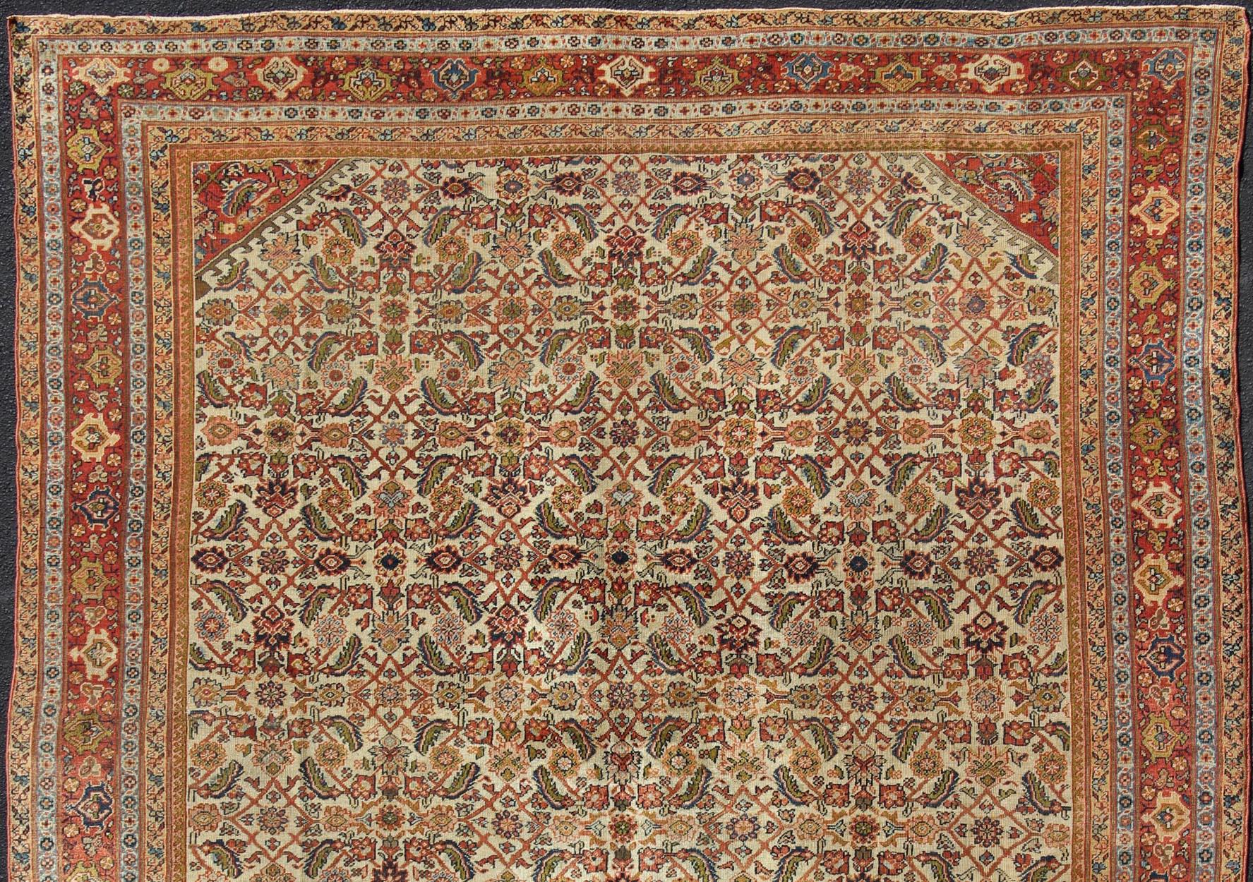 Alfombra persa antigua Ferahan con diseño Herati integral en marfil, coral y verde siglo XIX en venta