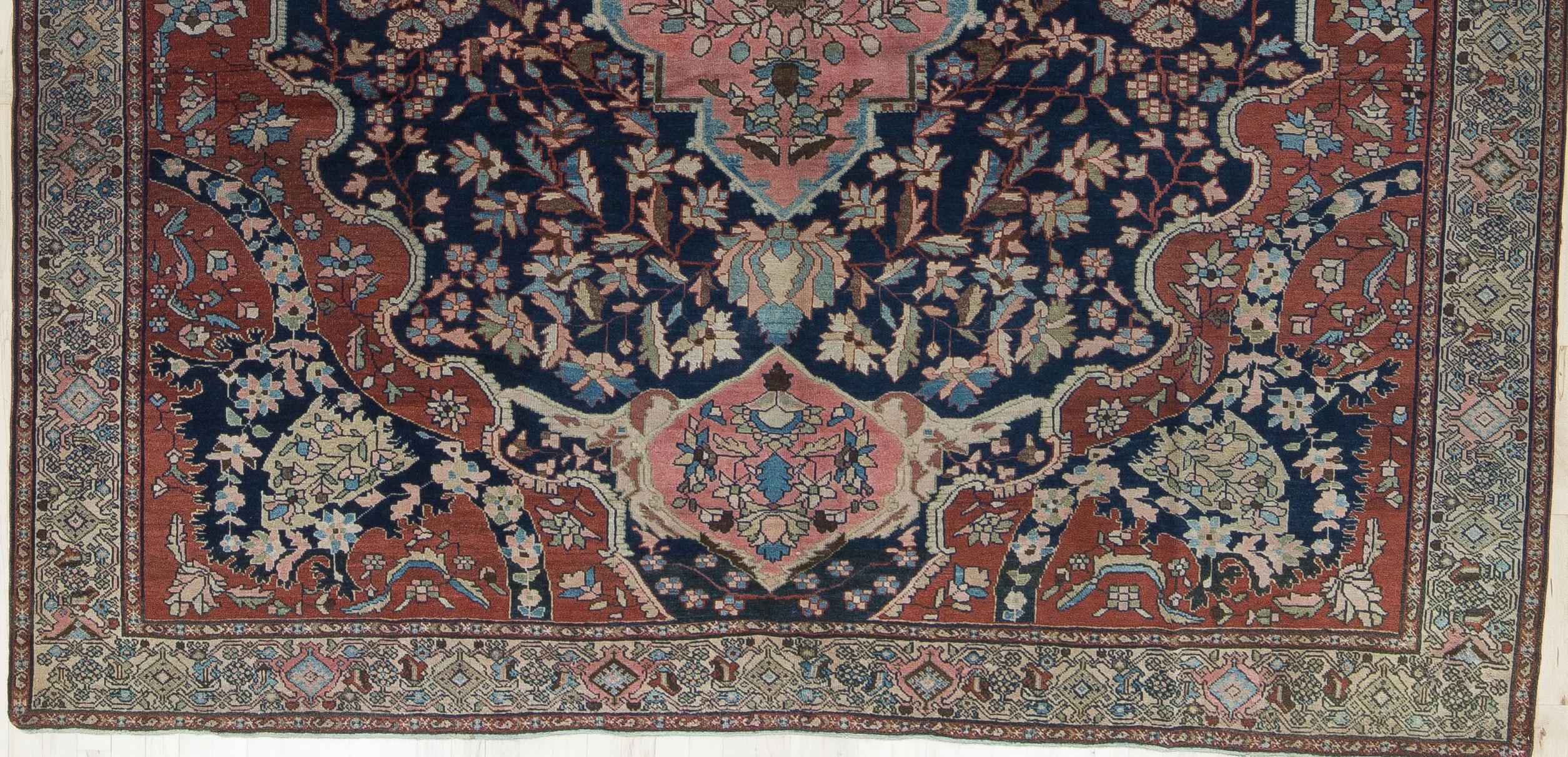 An early 19th Century Sarouk with deep navy, cornflower blue, jade green, shades of pink and ivory. A very finely woven rug with a low wool pile and delicate floral design. A classic, timeless piece. In beautiful condition with preserved sides and