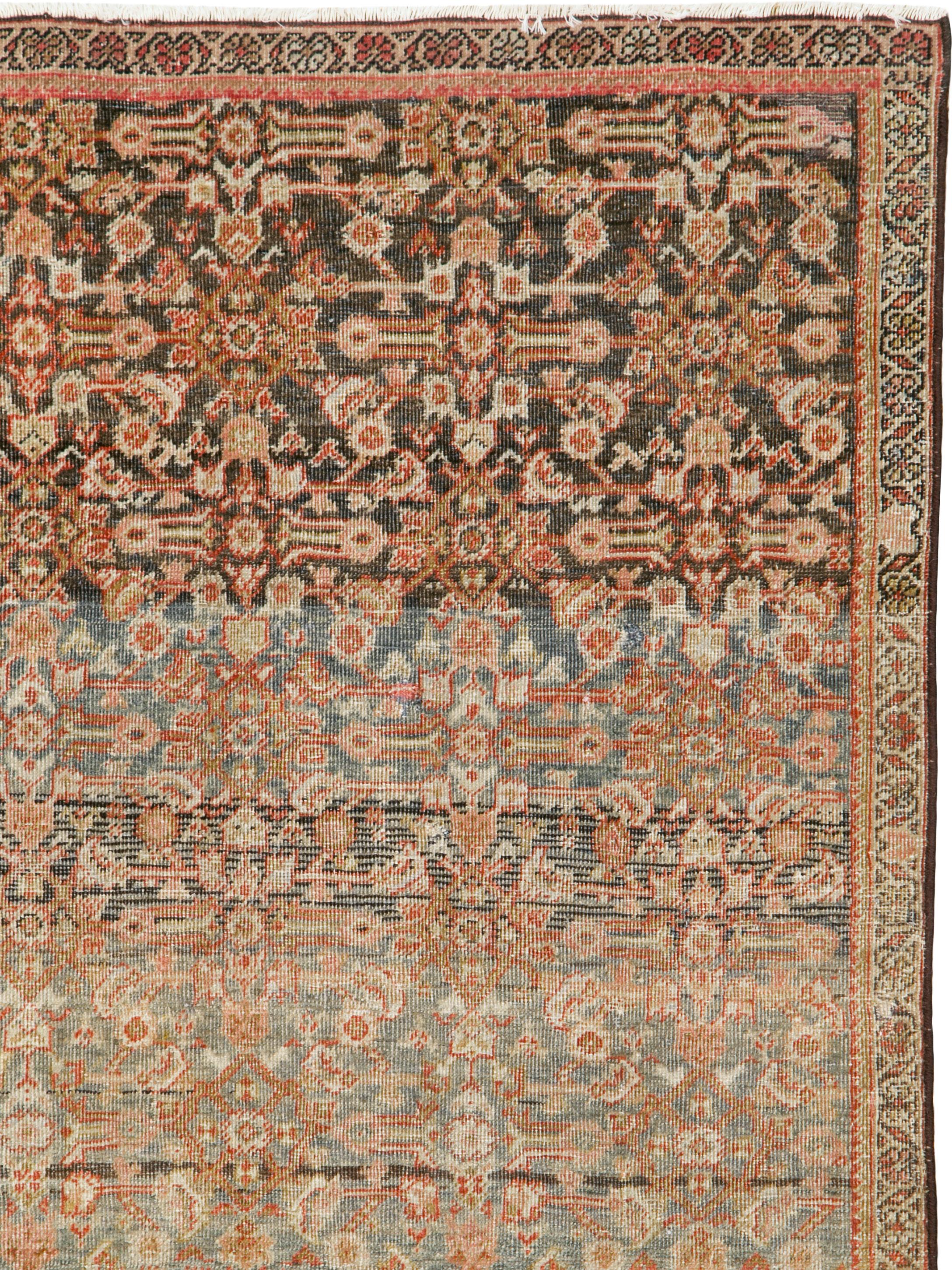 An antique Persian Fereghan rug from the late 19th century. Narrow ivory reversing fan palmette border discreetly frames the well-abrashed (natural color striation) slate field which is very closely covered by a balanced all-over Herati pattern