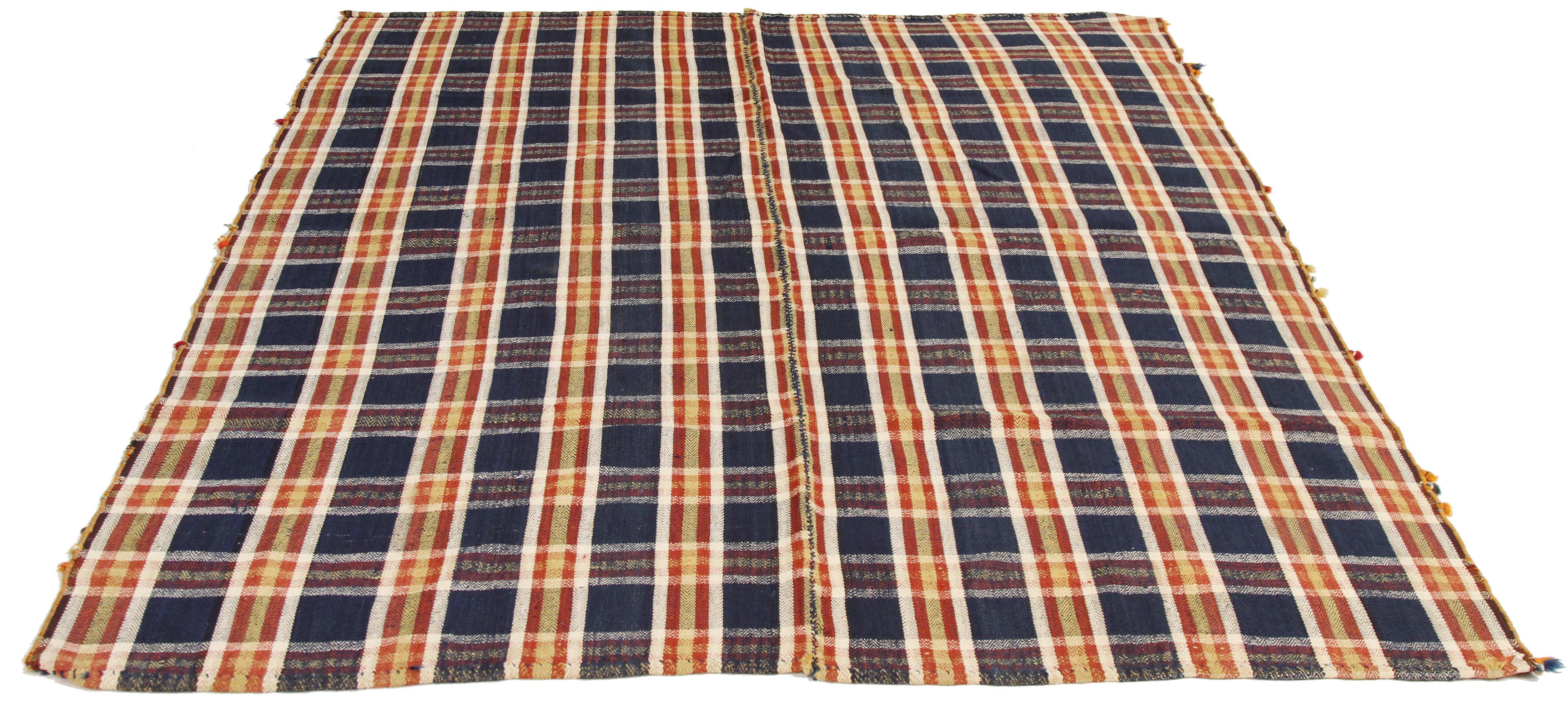 Antique Persian rug handwoven from the finest sheep’s wool and colored with all-natural vegetable dyes that are safe for humans and pets. It’s a traditional Jajim flat-weave design featuring navy and yellow chequered patterns. It’s a stunning piece